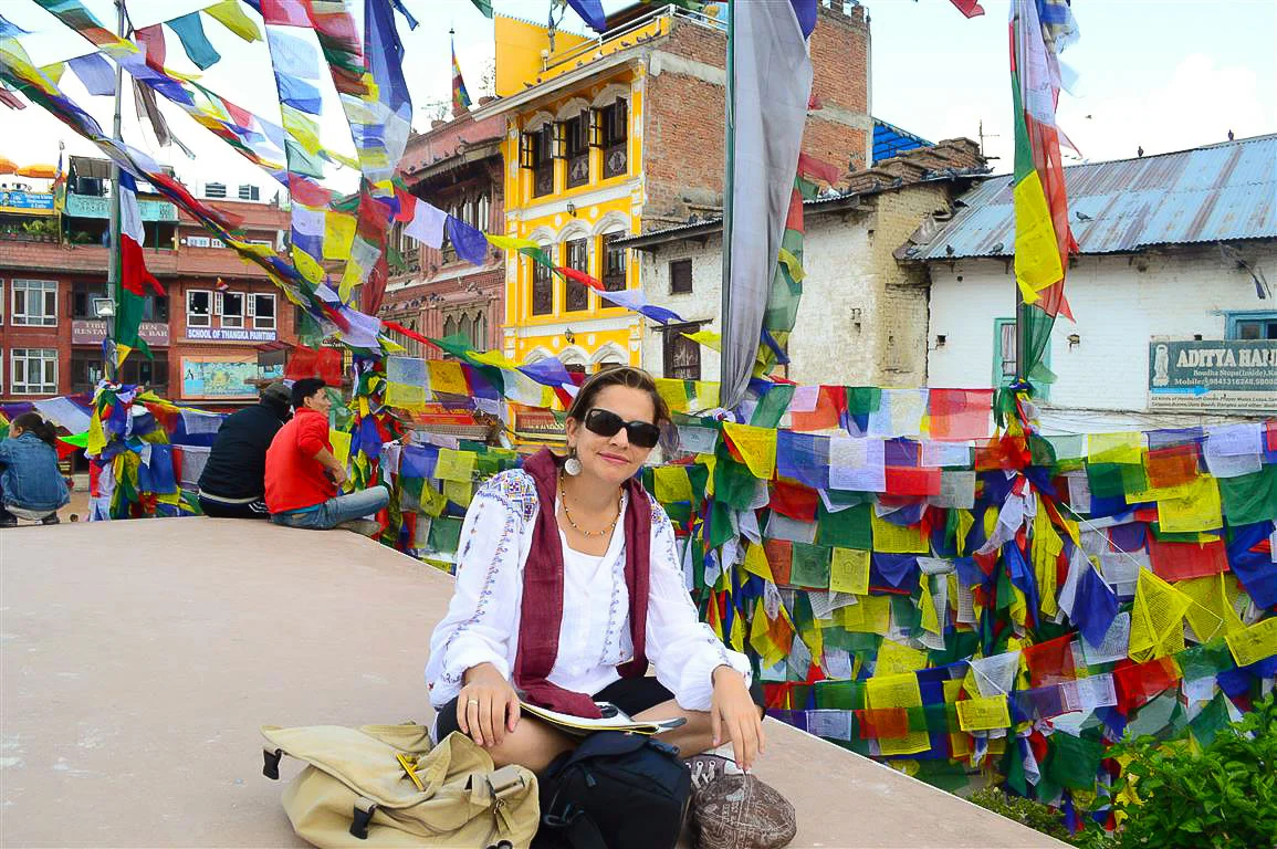 An emblematic view of Juanita and the prayer flags at the Bouddhanath Stupa in Kathmandu, Nepal