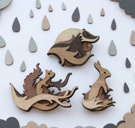 Tomsky Martin Tomsky creates illustrative, relief pieces from laser cut, stained plywood. These range from very small items of jewellery to much larger, bespoke artworks. Each piece is hand assembled to create an organic object that bridges the gap between craft, illustration and sculpture.