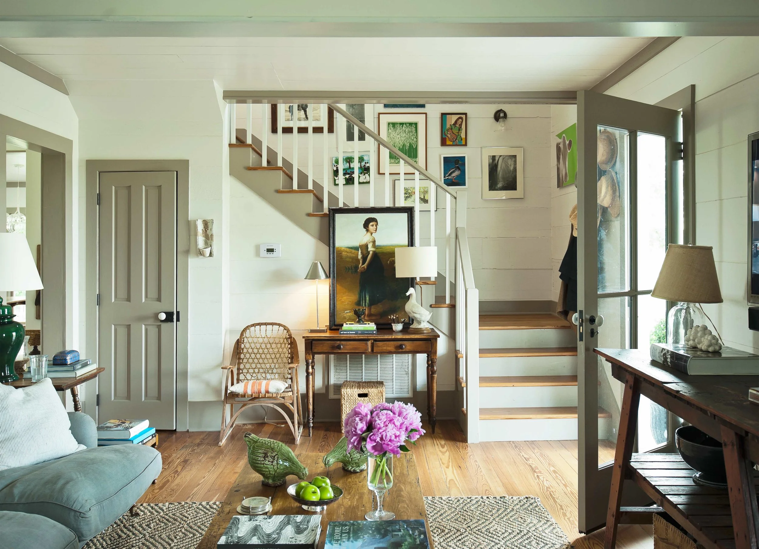The front door of the house opens directly into the living room. What might have been a deterrent for some, suits the family just fine as they run in and out of the house all day long and spend a good deal of time outdoors. A gallery wall of Ashley’s collection of funky artwork leads upstairs.