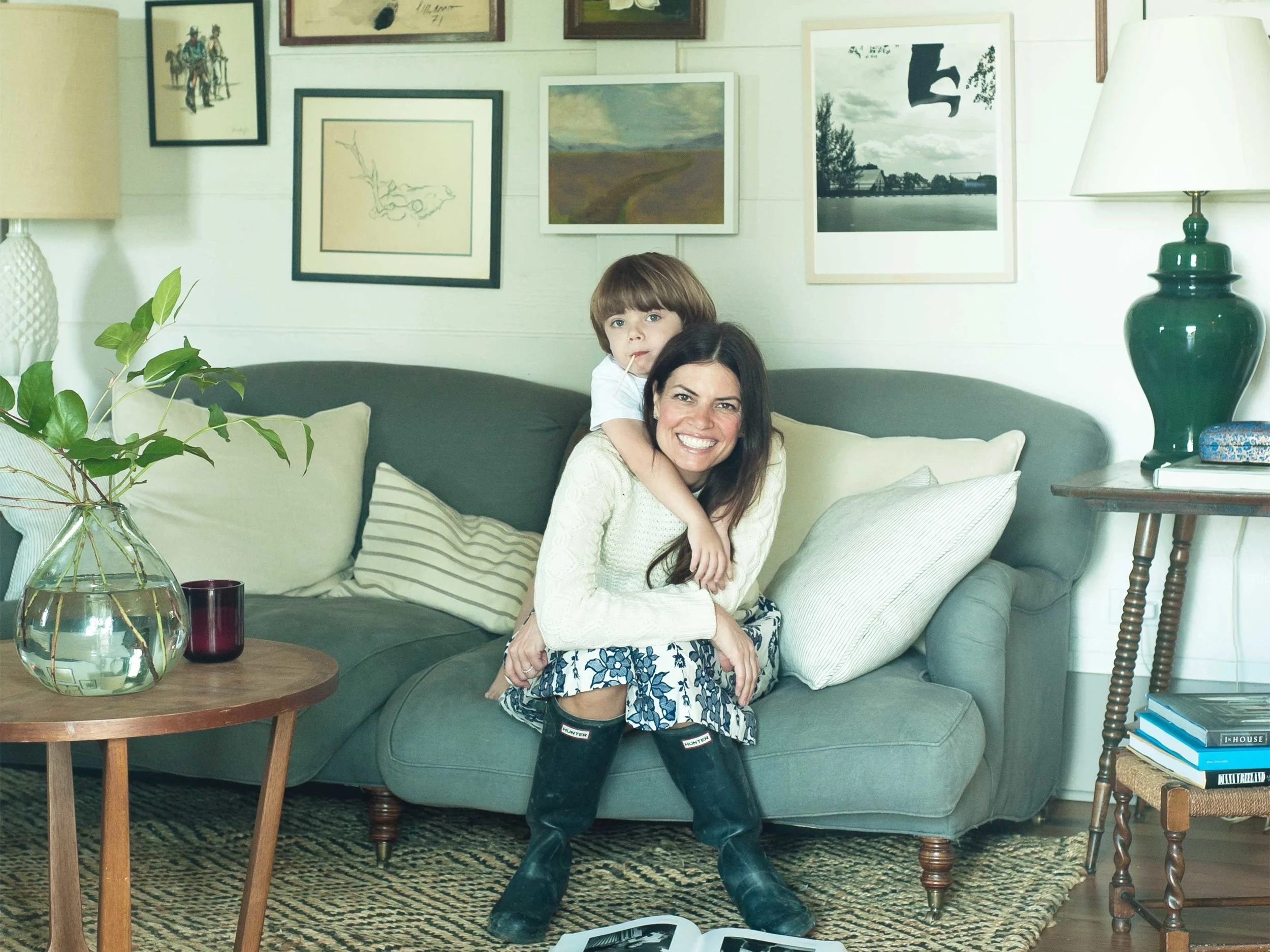 Putman romps in the living room with four-year-old son Scott. She committed to using white paint on the walls with a grey trim to create a light, airy space that she anchored with darker wood furniture. A mix of new furniture (the George Sherlock sofa), and antiques, and a whimsical collection of vintage and local artwork creates an affect that she calls “lived in, not stodgy.”