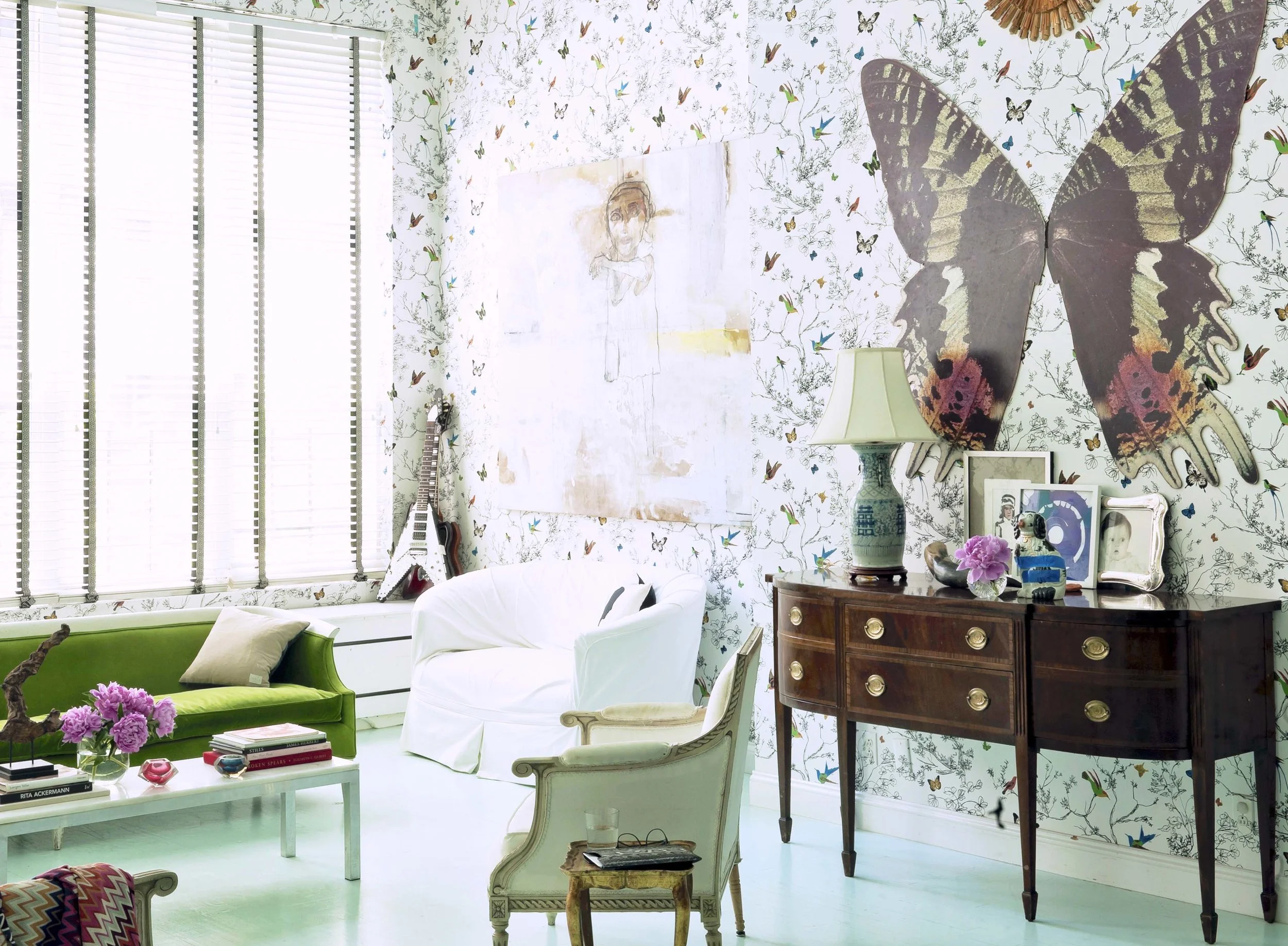 “We bought this loft after we got married and moved to Chelsea from the East Village. It was Phil who could see the potential and talked me into it. It had an enormous faux river rock wall in the middle of the space with a pentagram shaped mirror and stipple plaster that looked like Baked Alaska on the ceilings,” recalls Post. Yikes! Despite their disparate provenance (the giant butterfly was found on the street and the sideboard was inherited from Post’s grandmother) the furnishings feel unified thanks to Chassie’s decision to paint the ceilings and floors robin’s egg blue while keeping most of the upholstered pieces slipcovered in white