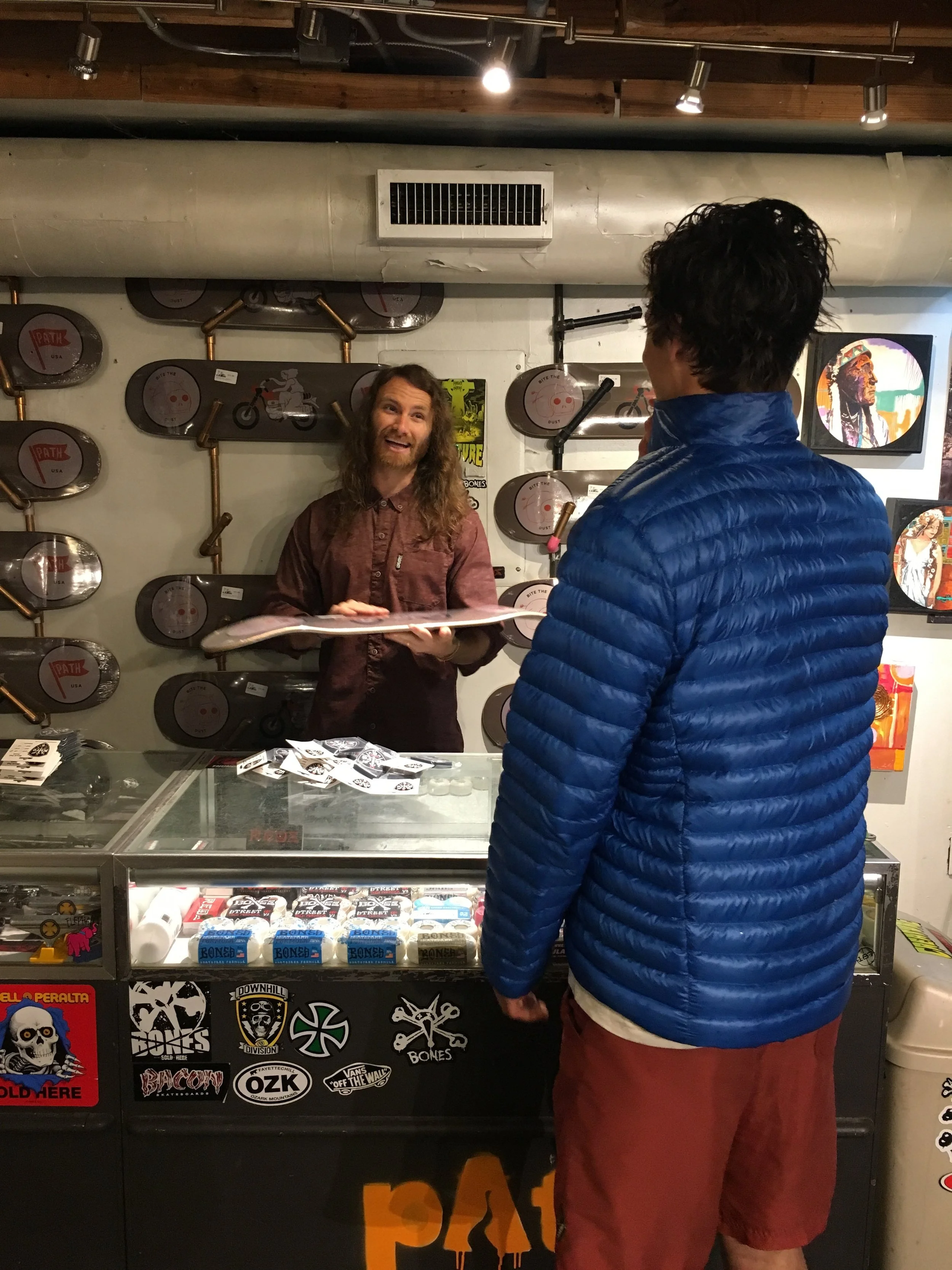 Matt Miller, back left, describes different sizes of skateboards and their importance on Friday, Apr. 21, 2017. The customer had never had a skateboard before, and was able to receive education at the shop.