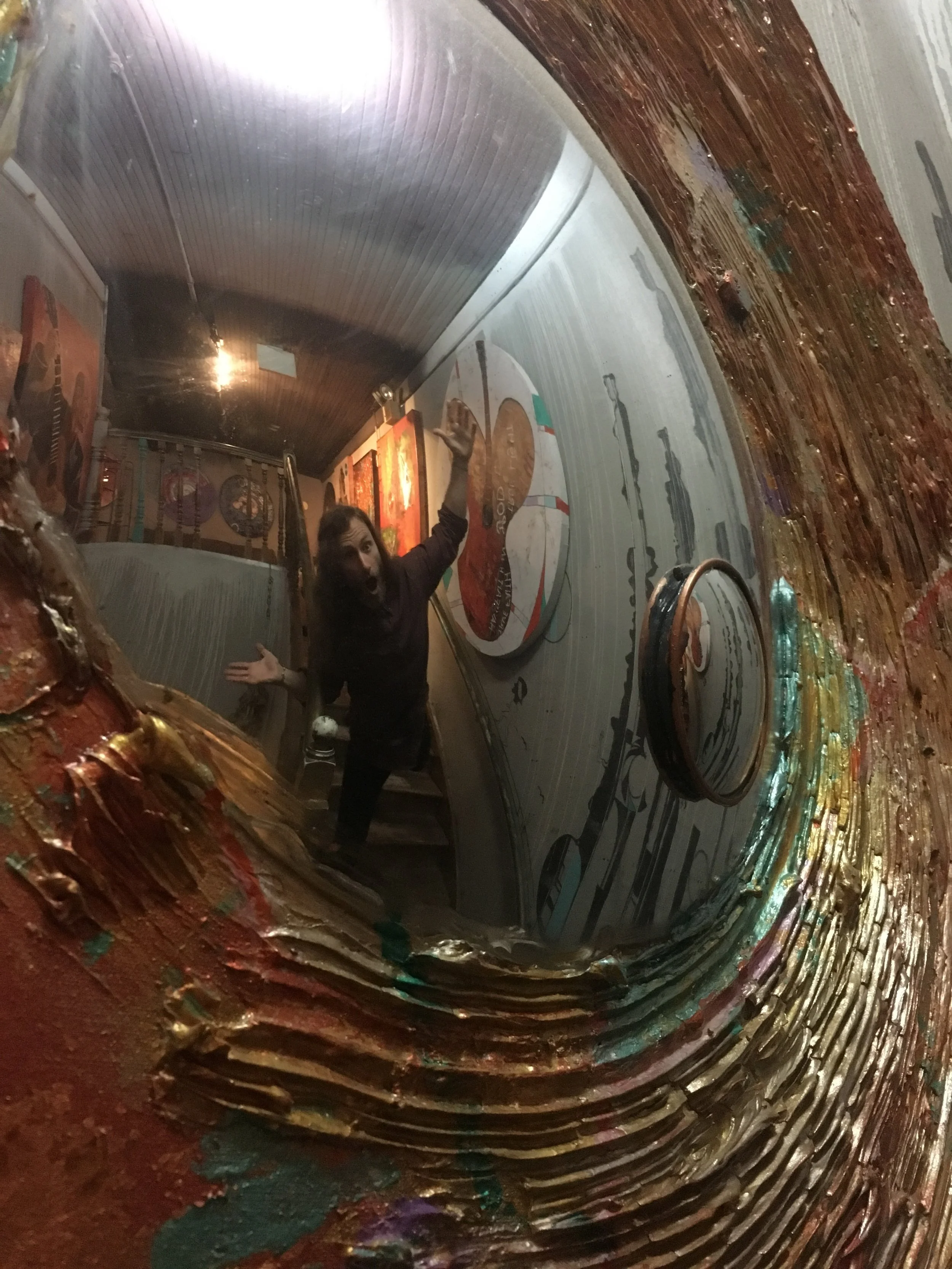 Matt Miller throws up a goofy pose in the mirror of one of his many paintings Friday, Apr. 21, 2017. Mr. Miller completed this specific piece around 3 years ago. It now hangs on display at Path Outfitters.
