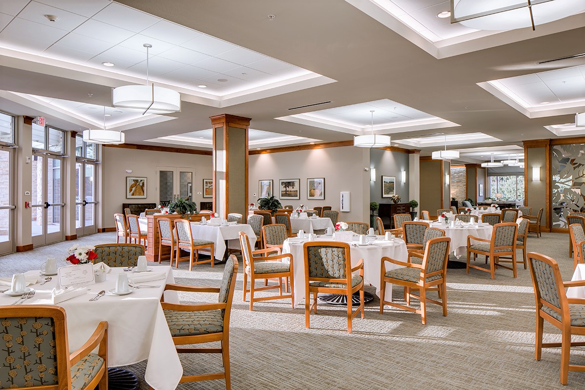 Dining room furnished with neutral furniture and soft lighting.