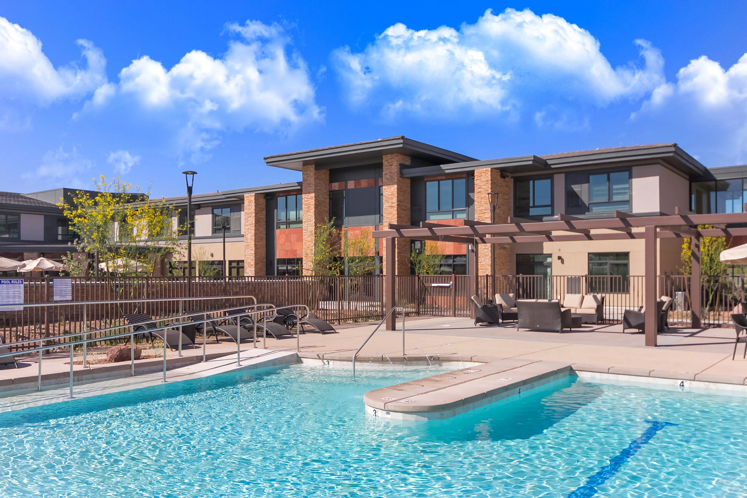 Merrill Gardens at Anthem The facade blends the desert setting by using Trelises with stucco walls, cultured stone veneer, and Sedona red sandstone.