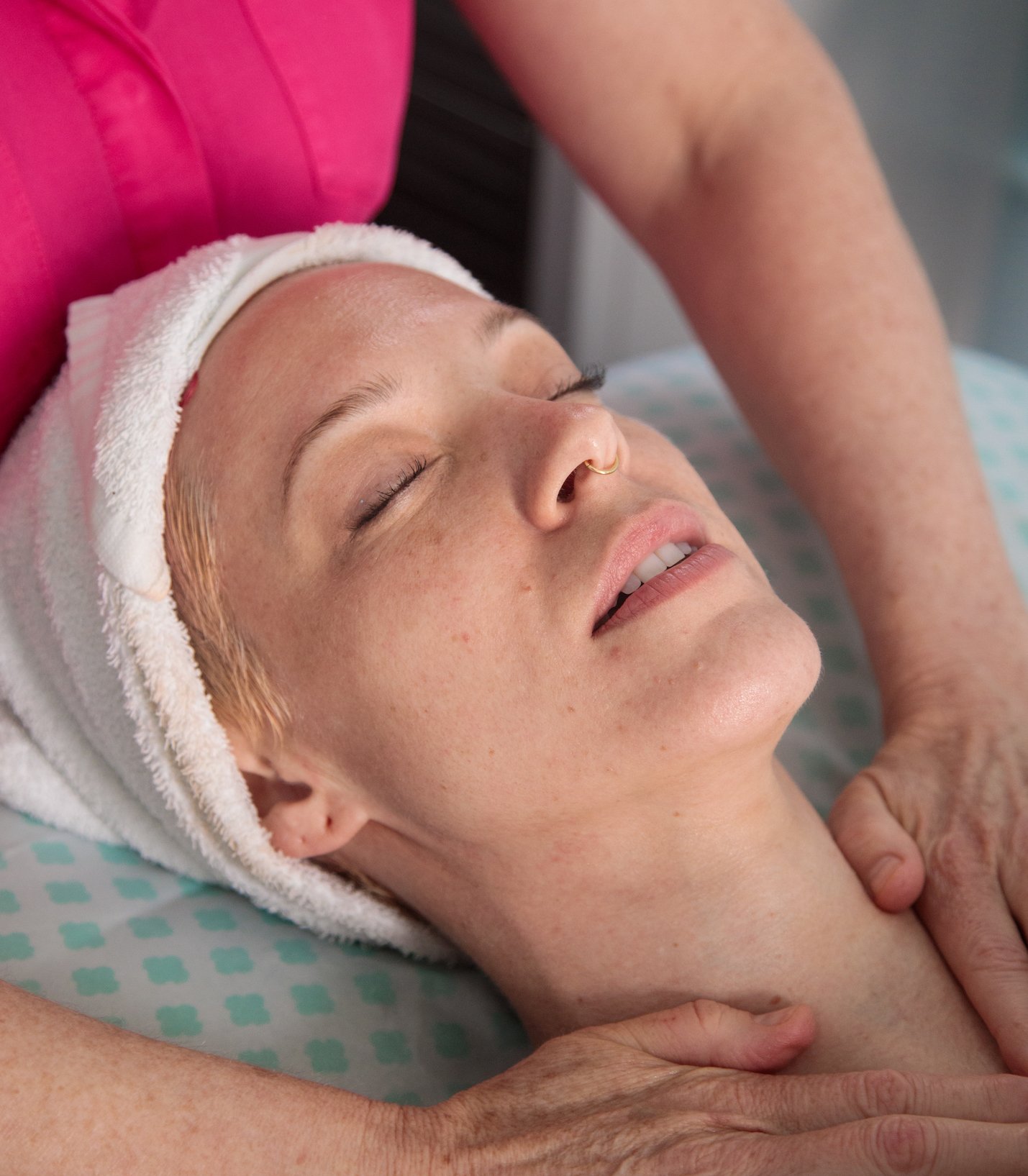 woman relaxing while getting a facial