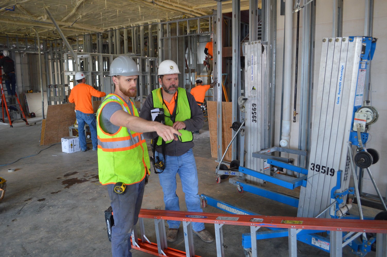 Cory Meyer of Modus Studio, the firm that designed Uptown Fayetteville Apartments + Shops, talks with a worker at the construction site.