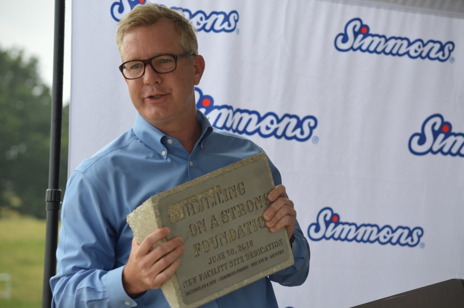 Todd Simmons, the CEO and vice chairman of Simmons Foods, holds one of the commemorative blocks that will be given to Benton County and the cities of Decatur and Gentry to show the company's commitment to building a strong foundation in each of the communities.