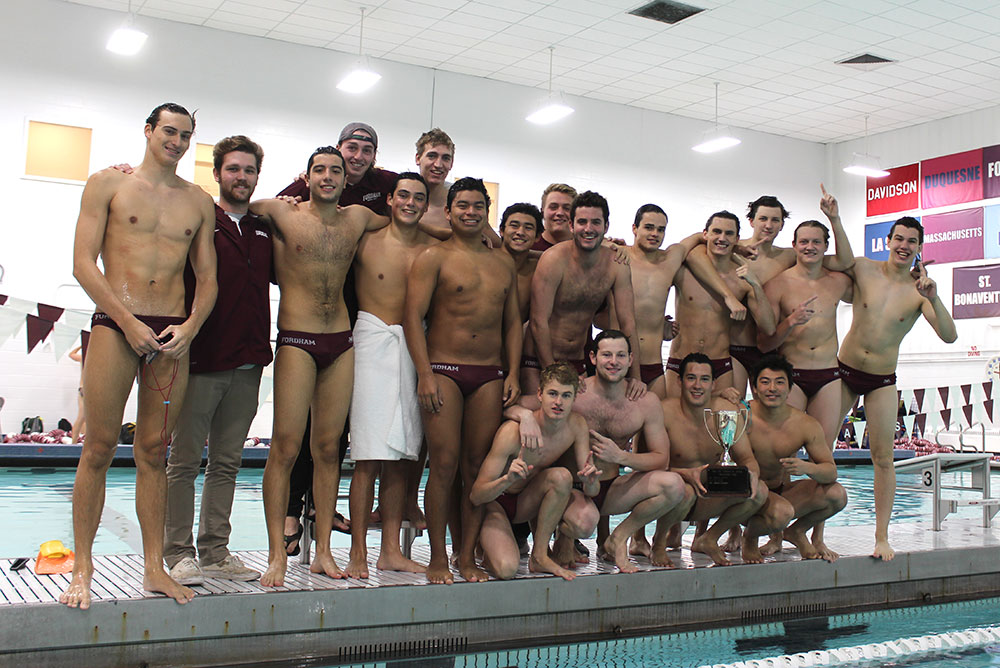 The men's water polo team at Fordham with the winning hardware from the 2016 Judge Cup