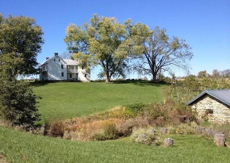 The house is surrounded by cornfields and other farms.