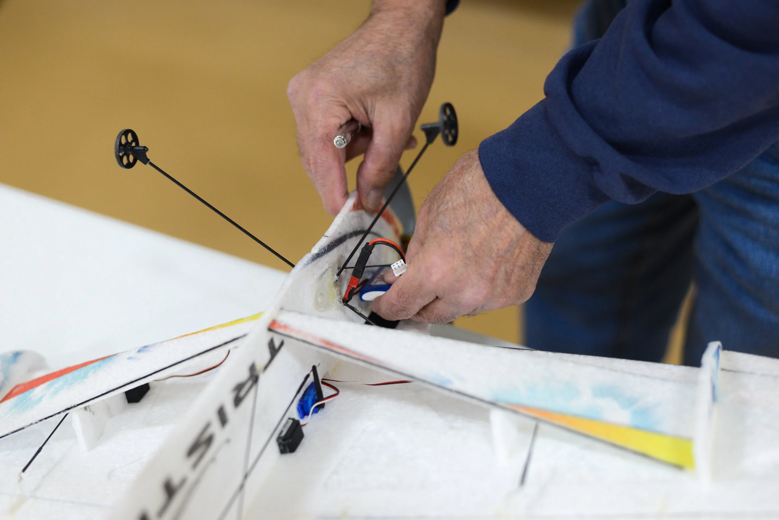  Glen Nyhus replaces a battery on his ultra-light RC plane on Saturday, Feb. 10. The plane only weights six ounces making it highly maneuverable. 