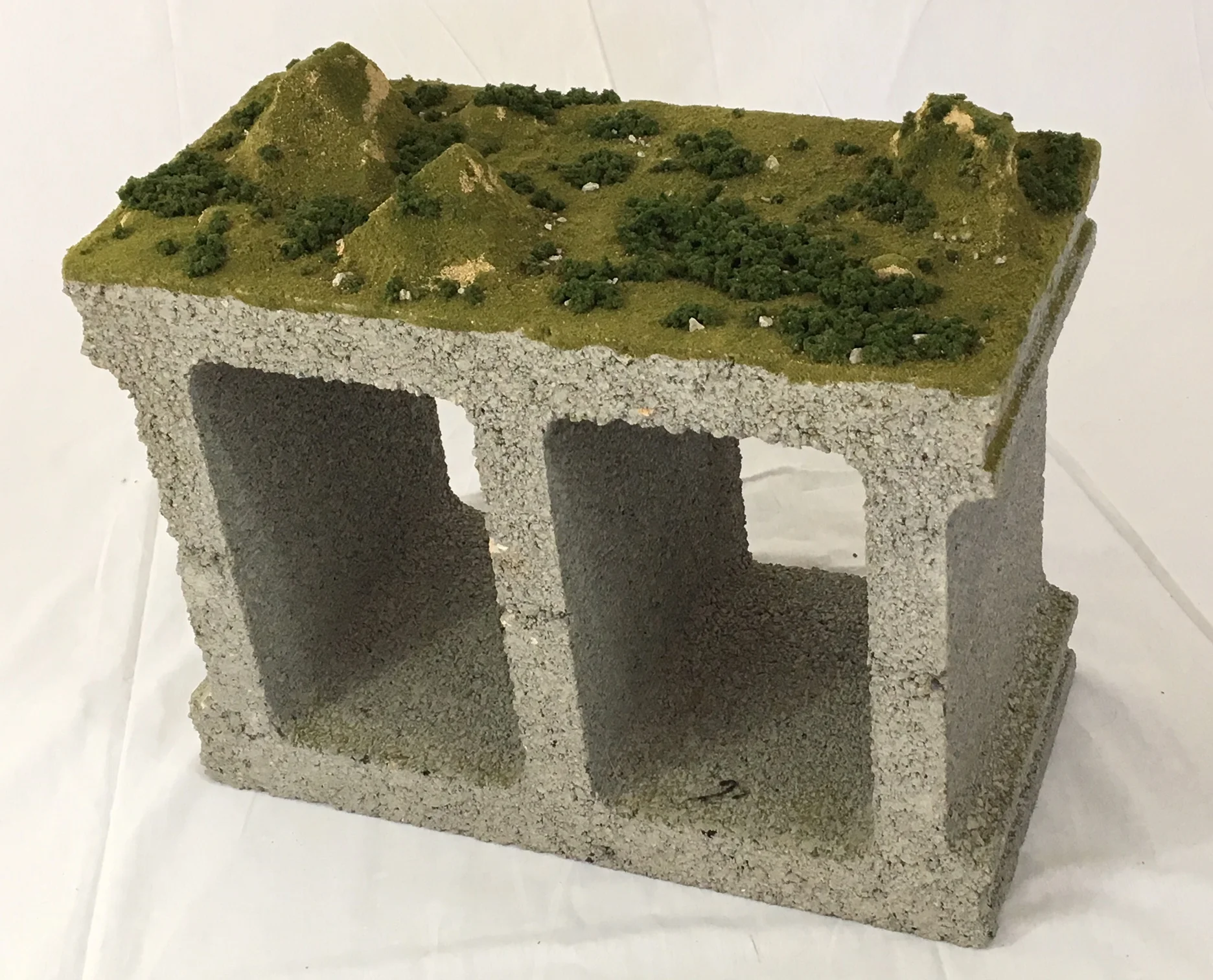 "Cinderscape" , 2017 Cinder block, model train landscape material, gel medium, 13"x19"x12" Courtesy Travis Childers and Carrie Able Gallery