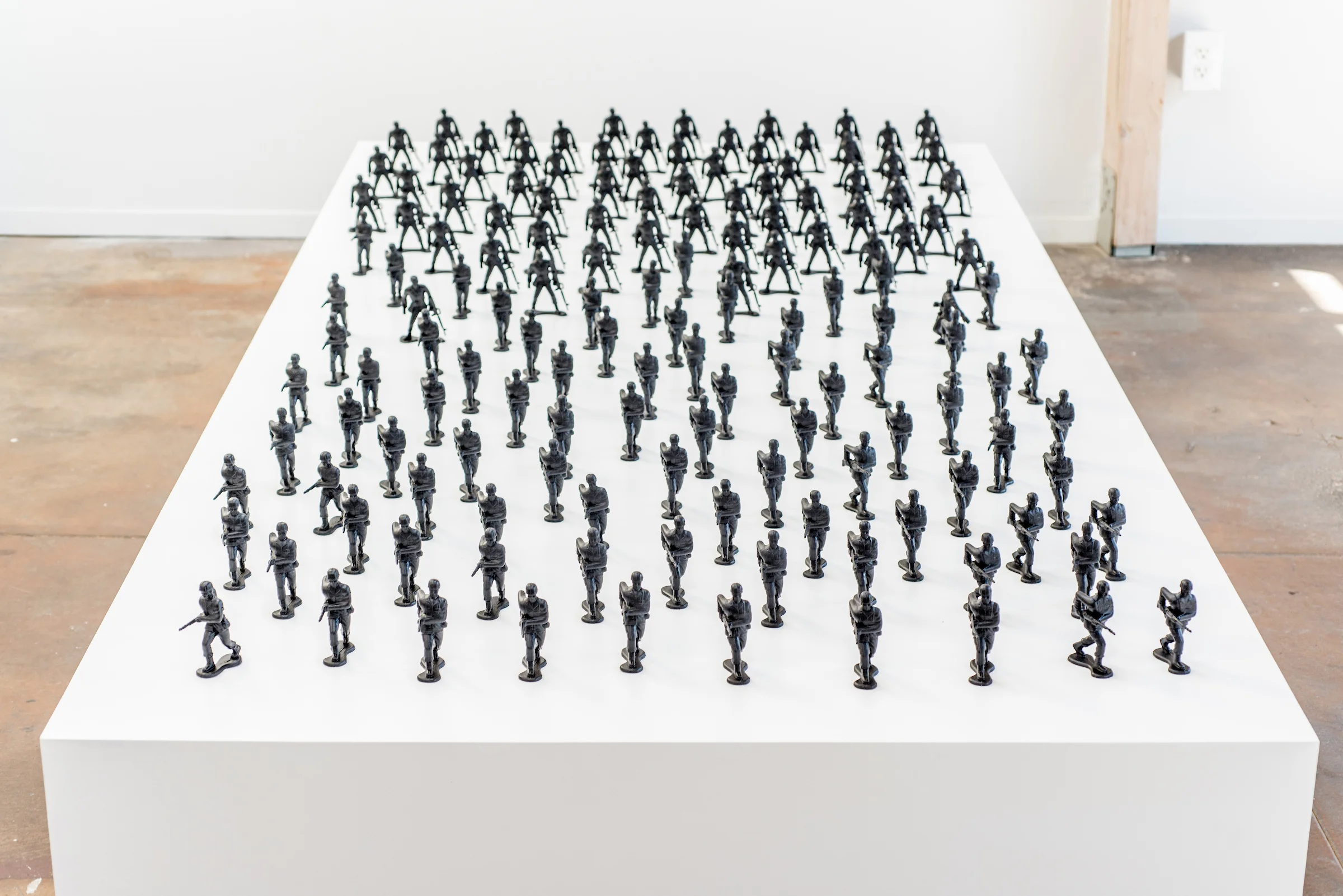 Installation View.Wooden platform with toy soldiers (4”), aerosol paint.