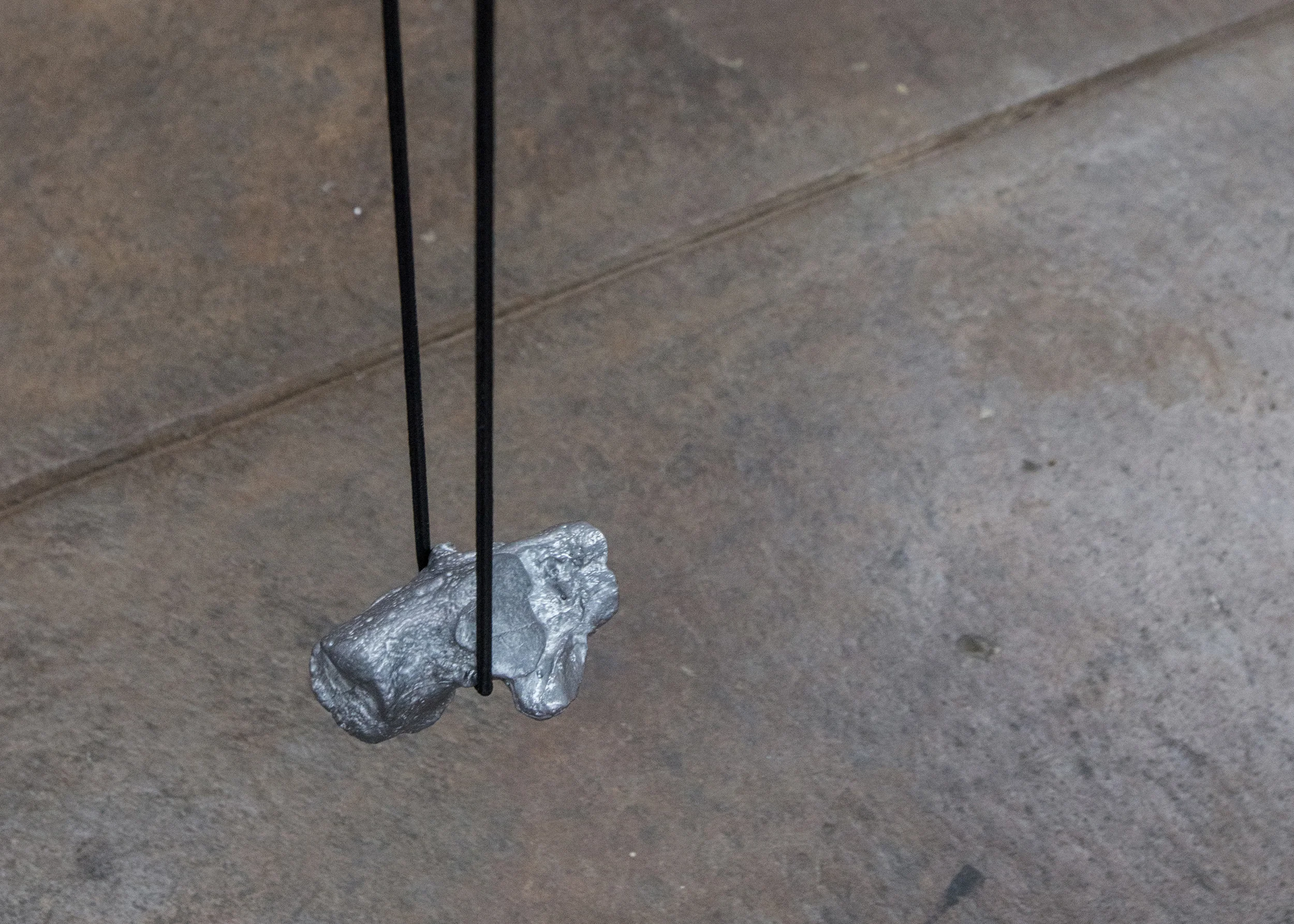 Lauren McKeon, Extension cord , 2019, lead cast heel bone, shock cord.