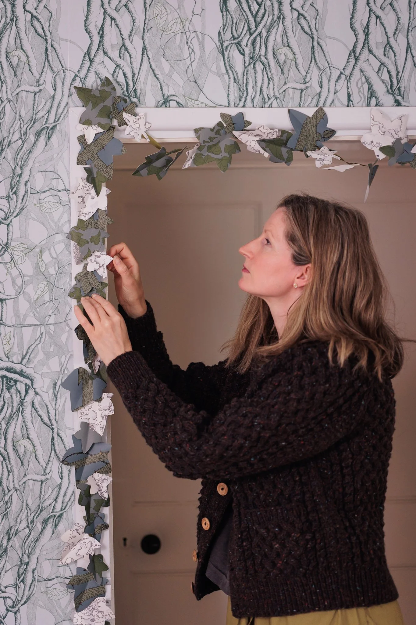 Designer Abigail Edwards showing how to make your own Christmas leaf garland with left over wallpaper off cuts.