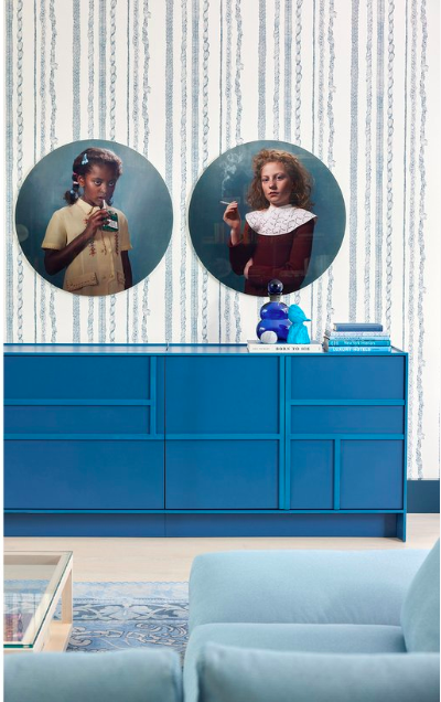 Rapunzel Stripe Wallpaper in a bespoke colour with blue credenza and sofa and photographic portraits on wall in a New York apartment