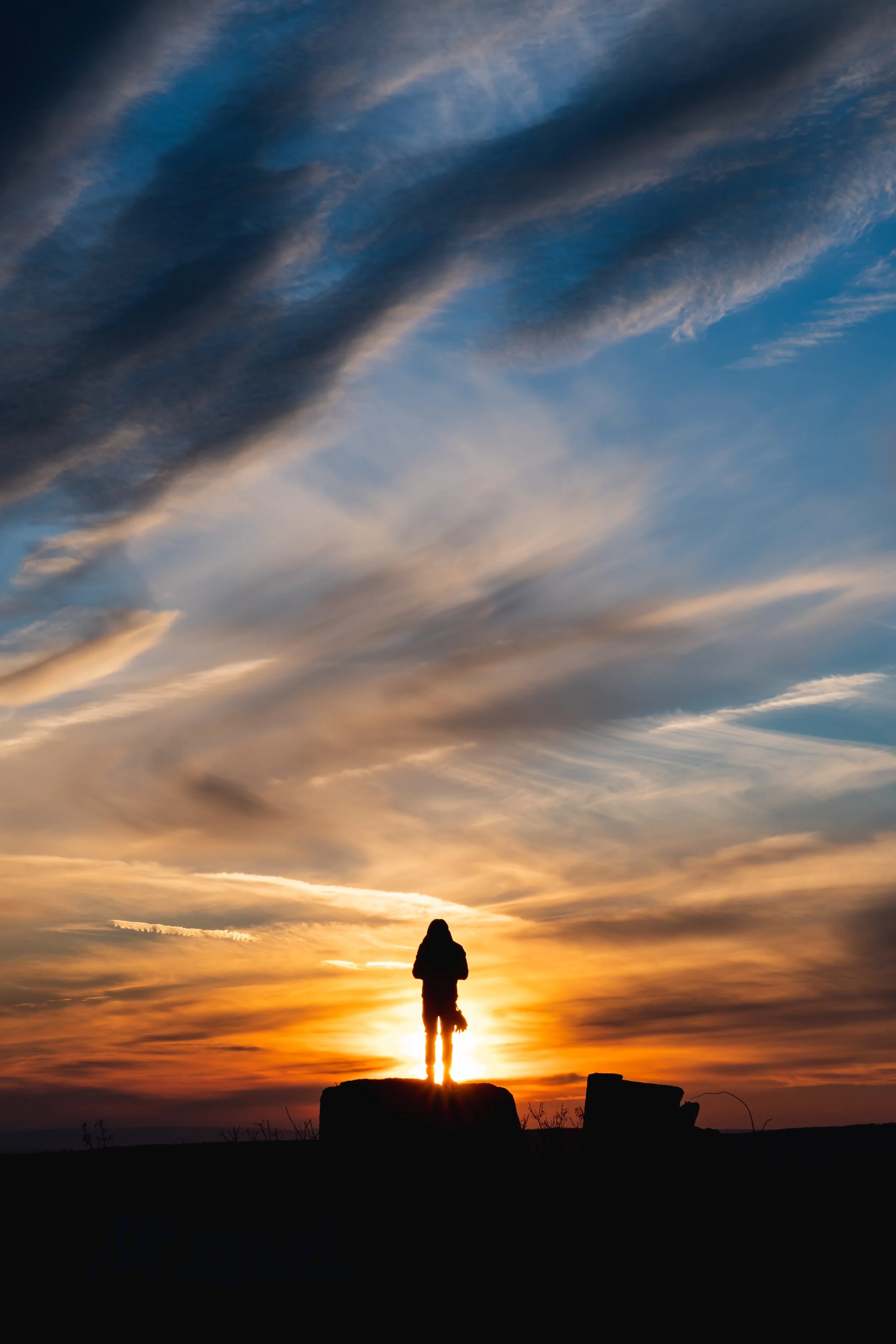 silhouette-of-a-person-standing-on-a-rock-3283907.jpg