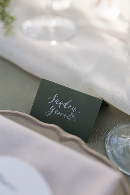  green place cards with white hand written calligraphy for a euro inspired wedding at the conservatory at blackberry ridge 