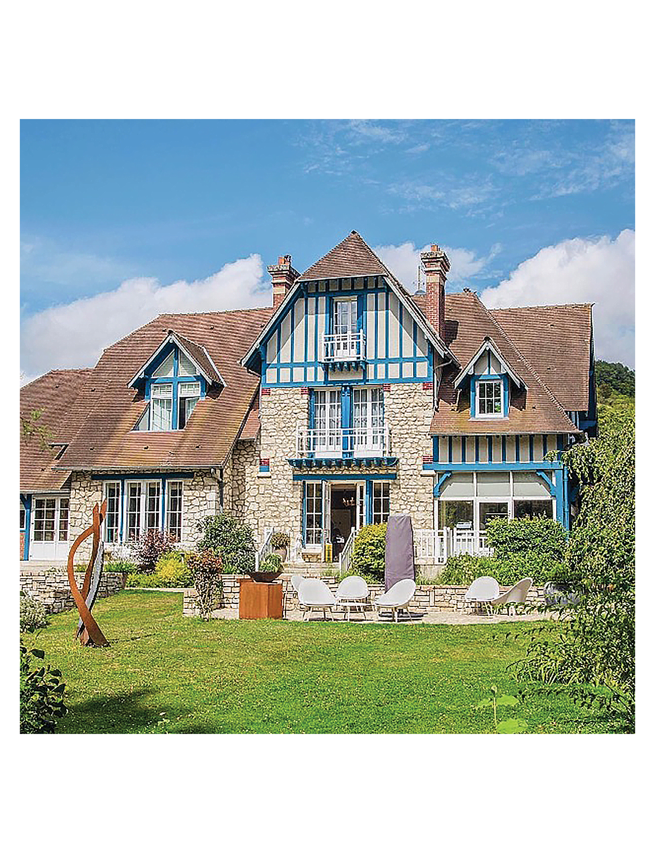the rear exterior and garden patio of Le Jardin des Plumes in Giverny, France, an Anglo-Norman style boutique hotel and Michelin-starred restaurant