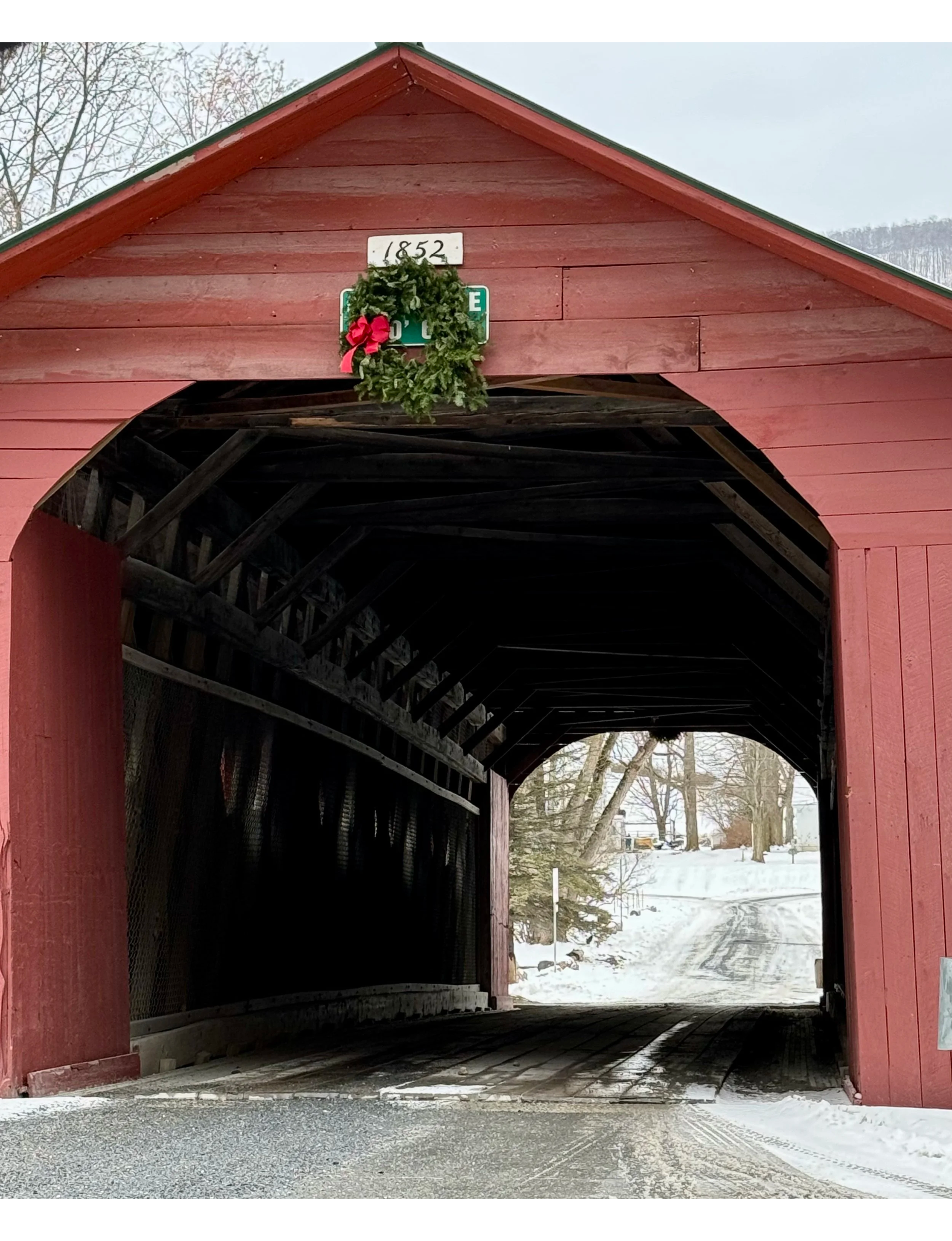 Vermont covered bridge in winter with Christmas wreath