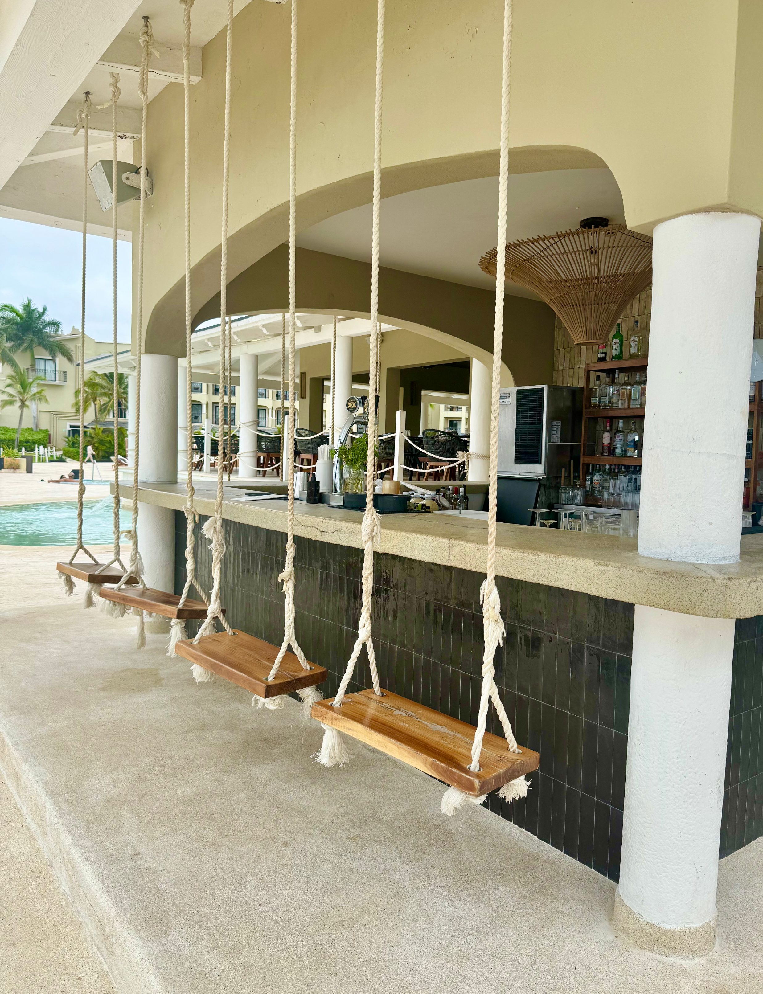 swing-style bar seating located at the Hyatt Zilara Riviera Maya resort in Mexico
