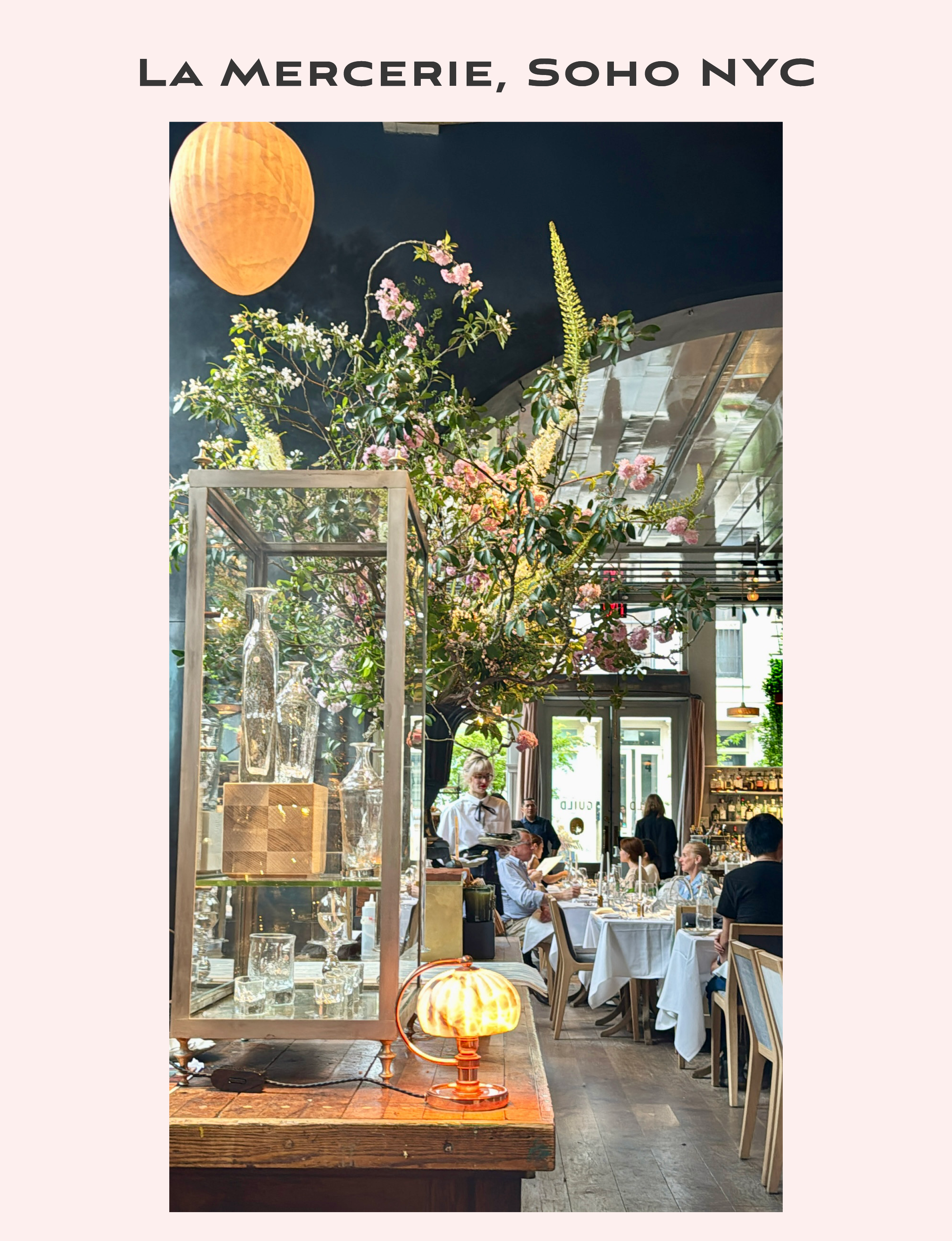 the elegant interior of La Mercerie, a chic French cafe and restaurant located in SoHo, New York City, renowned for its stunning floral arrangements, ambient lighting, and sophisticated European-style bistro atmosphere