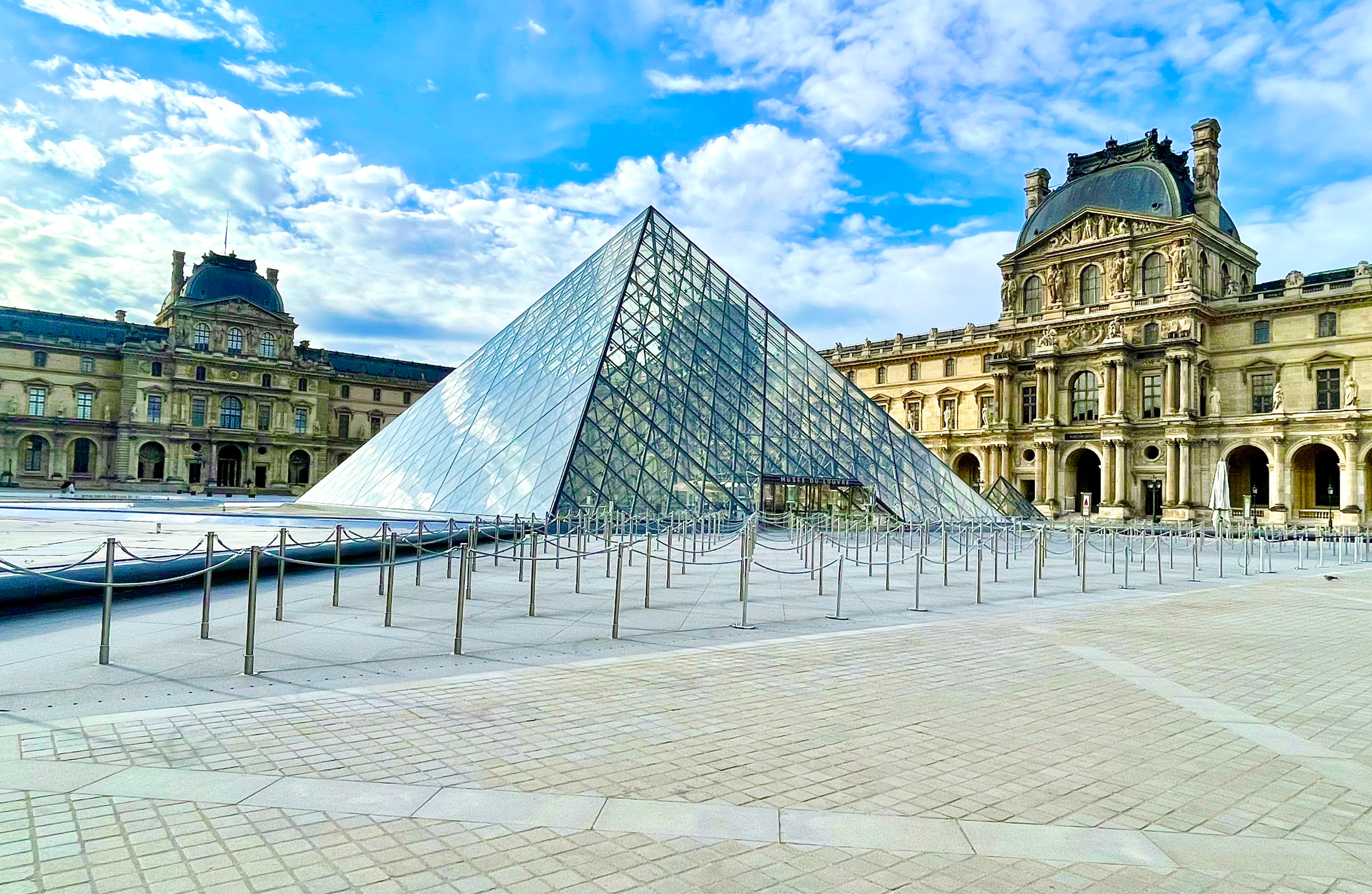The Louvre Pyramid, a famous large glass and metal pyramid in the main courtyard of the Louvre Museum in Paris, France. It acts as the primary entrance to the world's largest art museum
