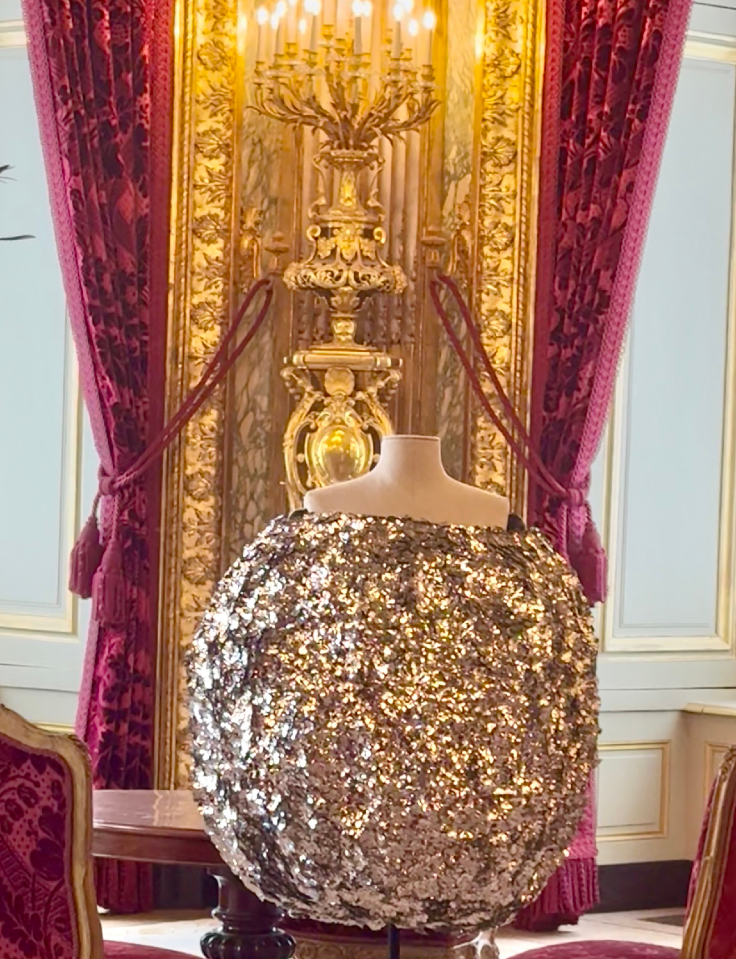 this metallic sequin sphere dress is a standout sculptural design by Jacquemus from their Fall/Winter 2023–2024 collection, shown here on display during the "Louvre Couture" exhibition at the Musée du Louvre