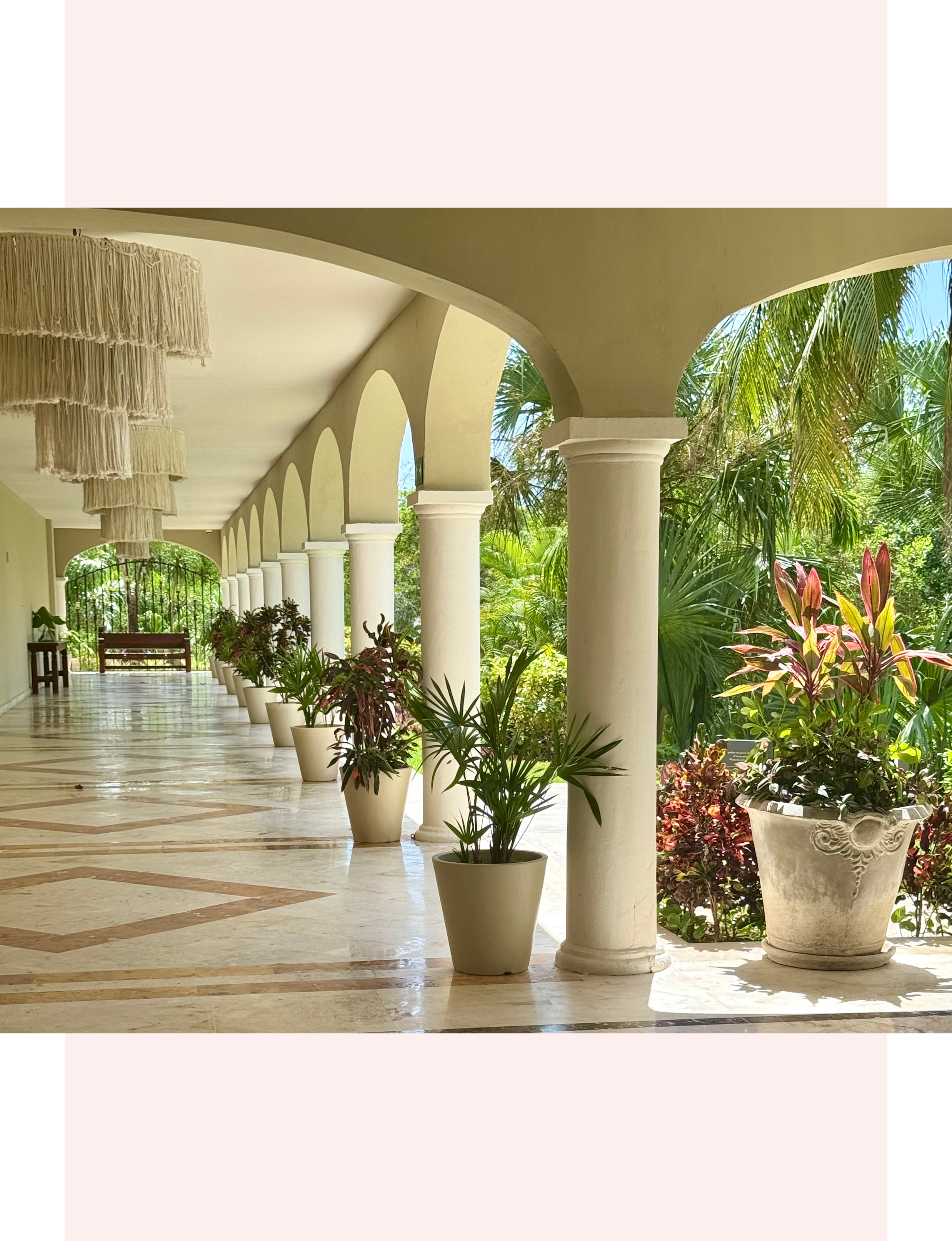 open-air colonnade walkway with arched pillars, tiled floors, and potted tropical plants at the Hyatt Zilara Riviera Maya resort in Mexico