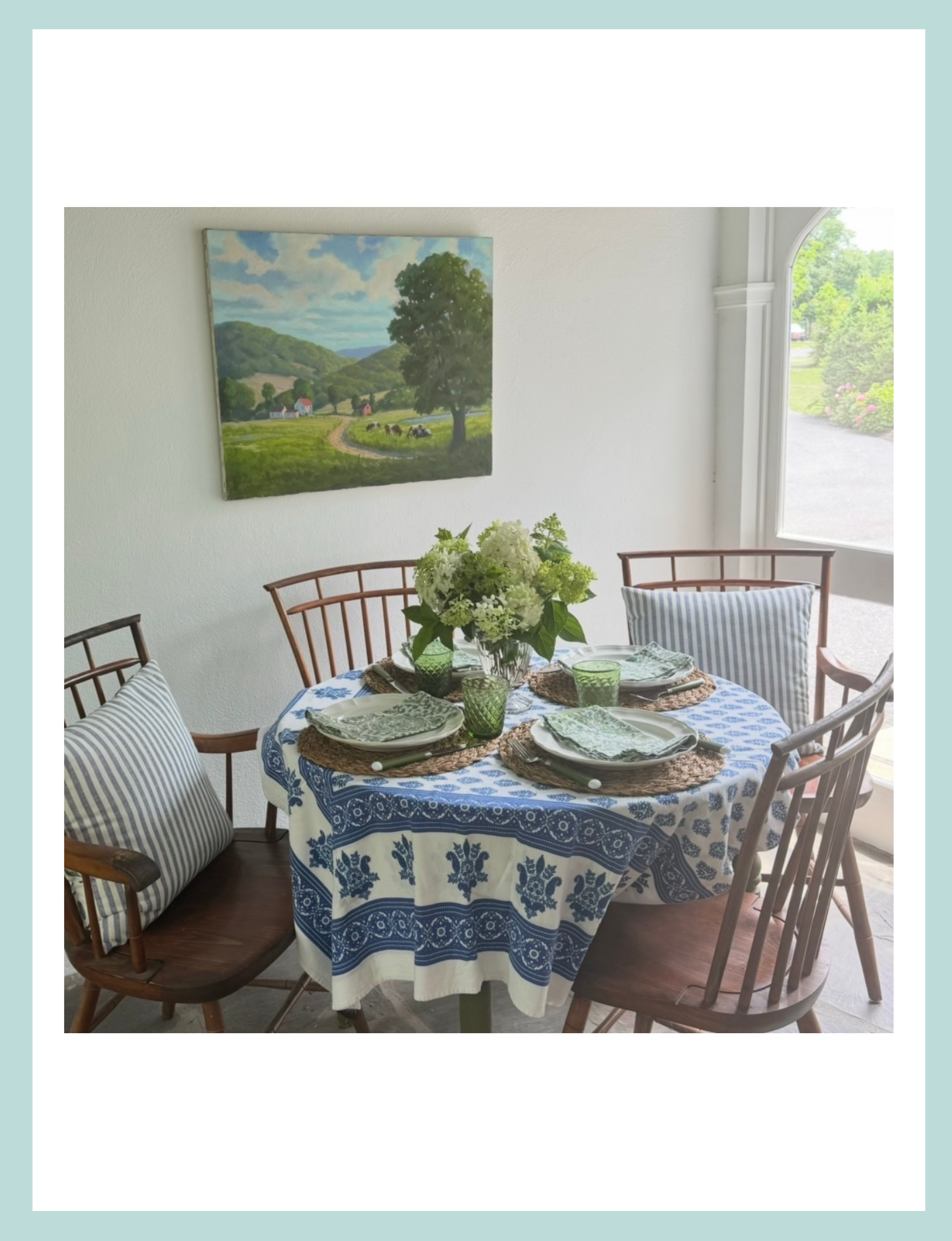 kitchen table with live flowers, blue tablecloth, summer artwork