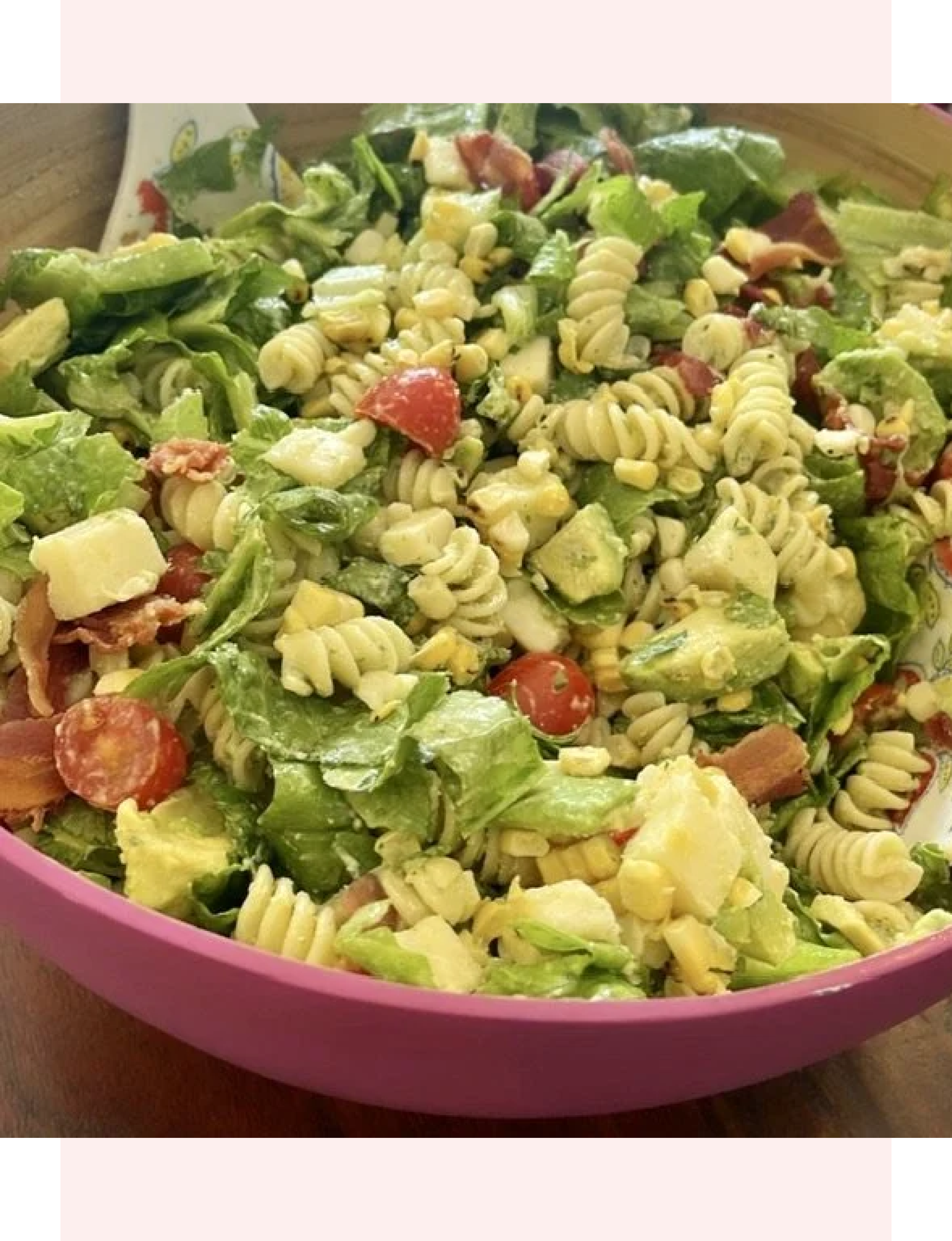 BLT pasta featuring Rotini/fusilli pasta, chopped romaine, crispy bacon, cherry tomatoes, diced avocado, and sweet corn tossed in a creamy herb, avocado-ranch, or mayo-based dressing