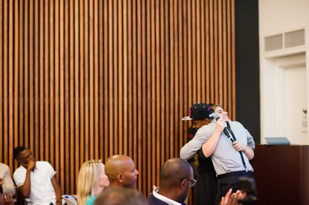  2017 Showcase: Cory Greene, H.O.L.L.A.!, hugs Yannell Selman, P.S. 305,&nbsp;while passing the mic for her pitch 