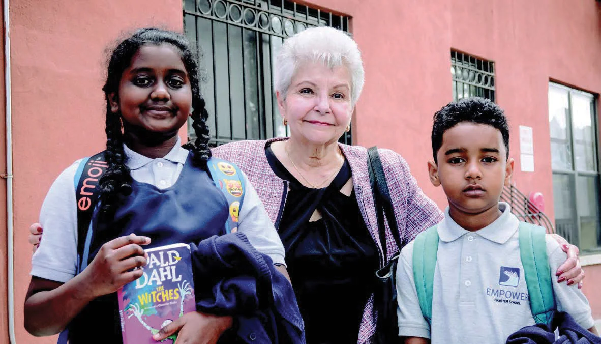Maria Rosado (with two neighborhood school children) efforts in affordable housing will be recognized at this year’s celebration. She is in front of one of her buildings at 2187 Strauss Street in Brownsville.