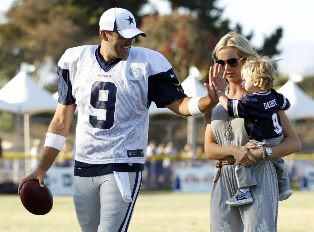 Dallas Cowboys quarterback Tony Romo (9) plays with his son Hawkins Romo, 1, as his wife Candice Romo holds Hawkins after the afternoon practice at Dallas Cowboys training camp in Oxnard, California on July 30, 2013. (Vernon Bryant/The Dallas Morning News) 03202014xBRIEFING
