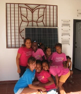  "Mariposas" taking photos in front of a solar panel after the install. 