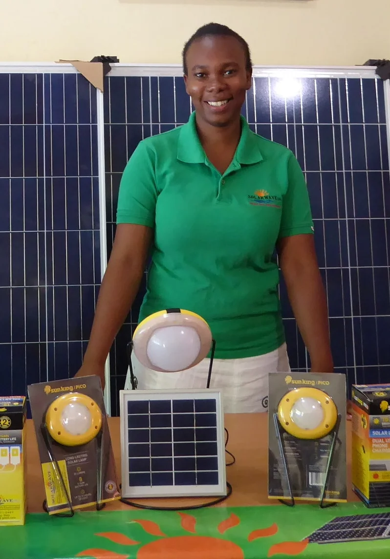  Young Haitian woman showing the latest in solar lamps.&nbsp; 