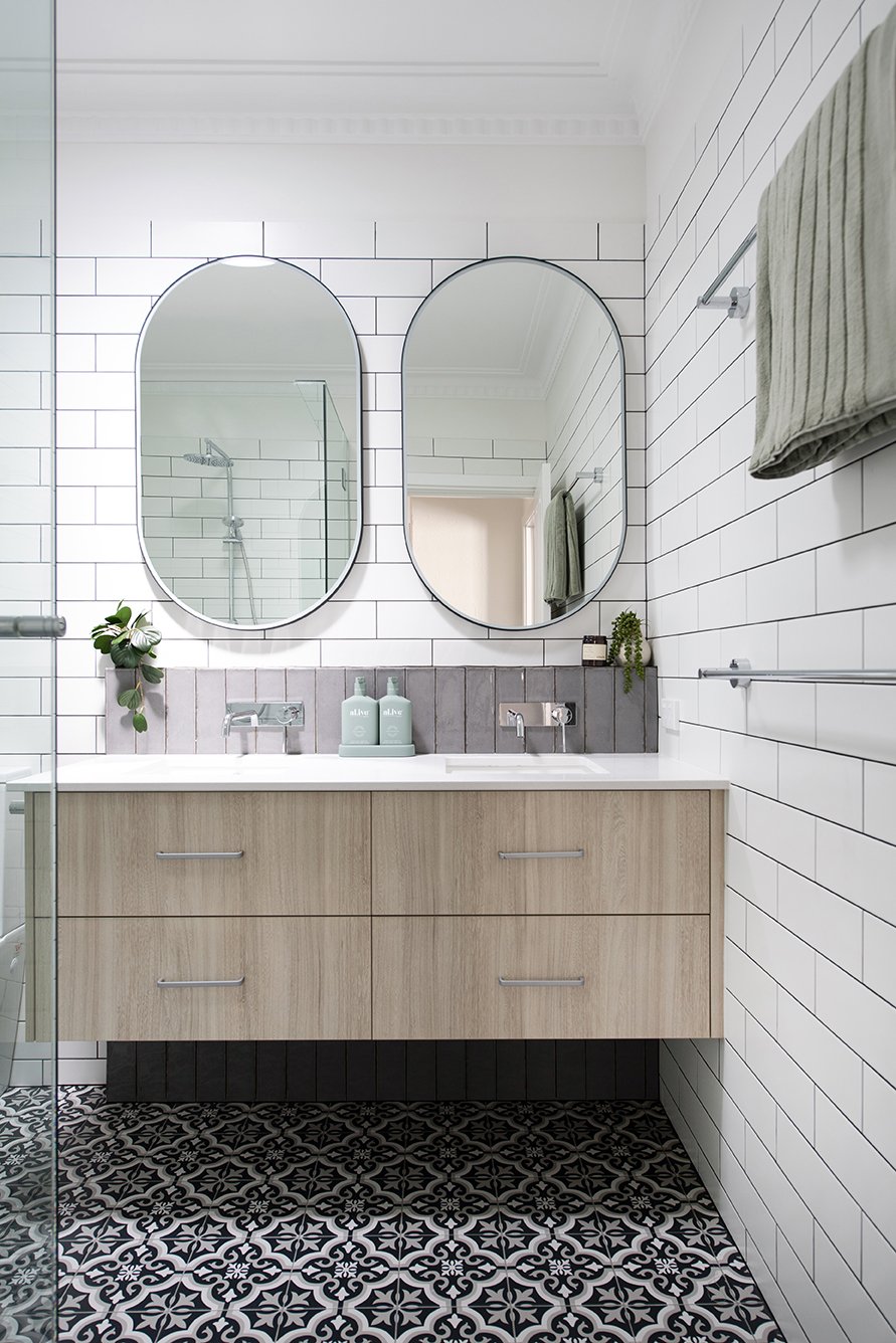 modern bathroom renovation white subway tiles oak vanity pill shaped mirrors encaustic tiled floor
