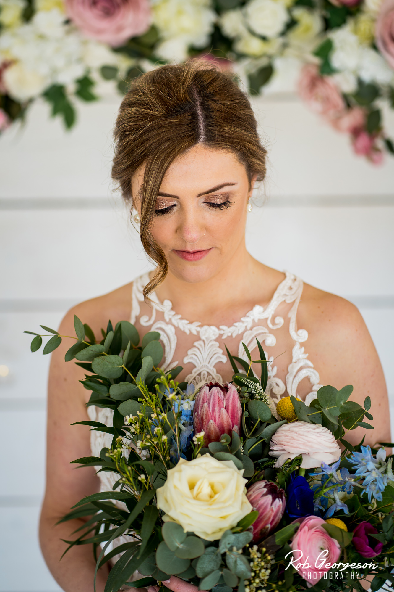 bashall barn bride looking at her flower bouquet