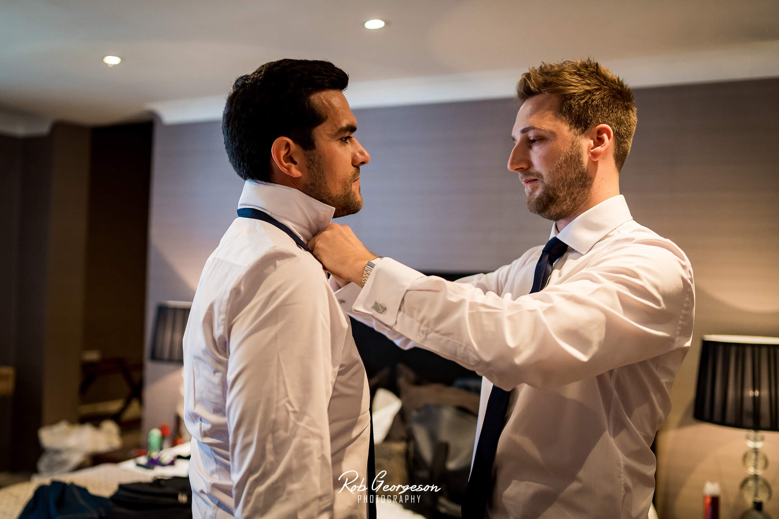 groomsmen putting on their tie