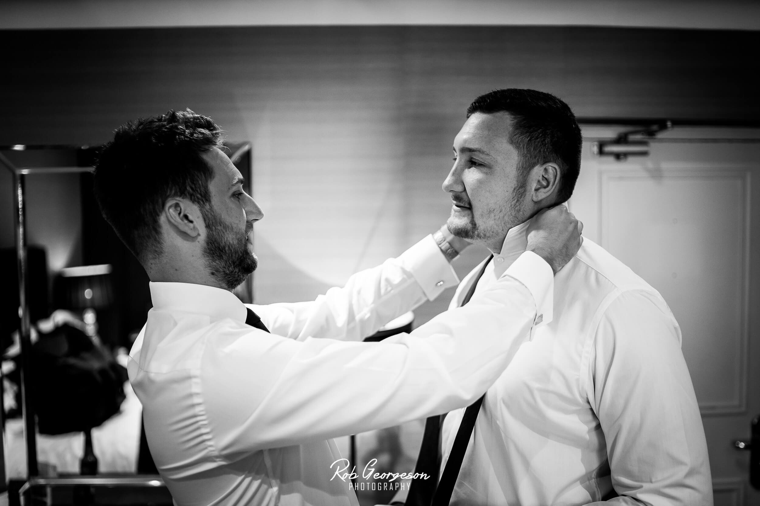 best man putting his wedding suit on