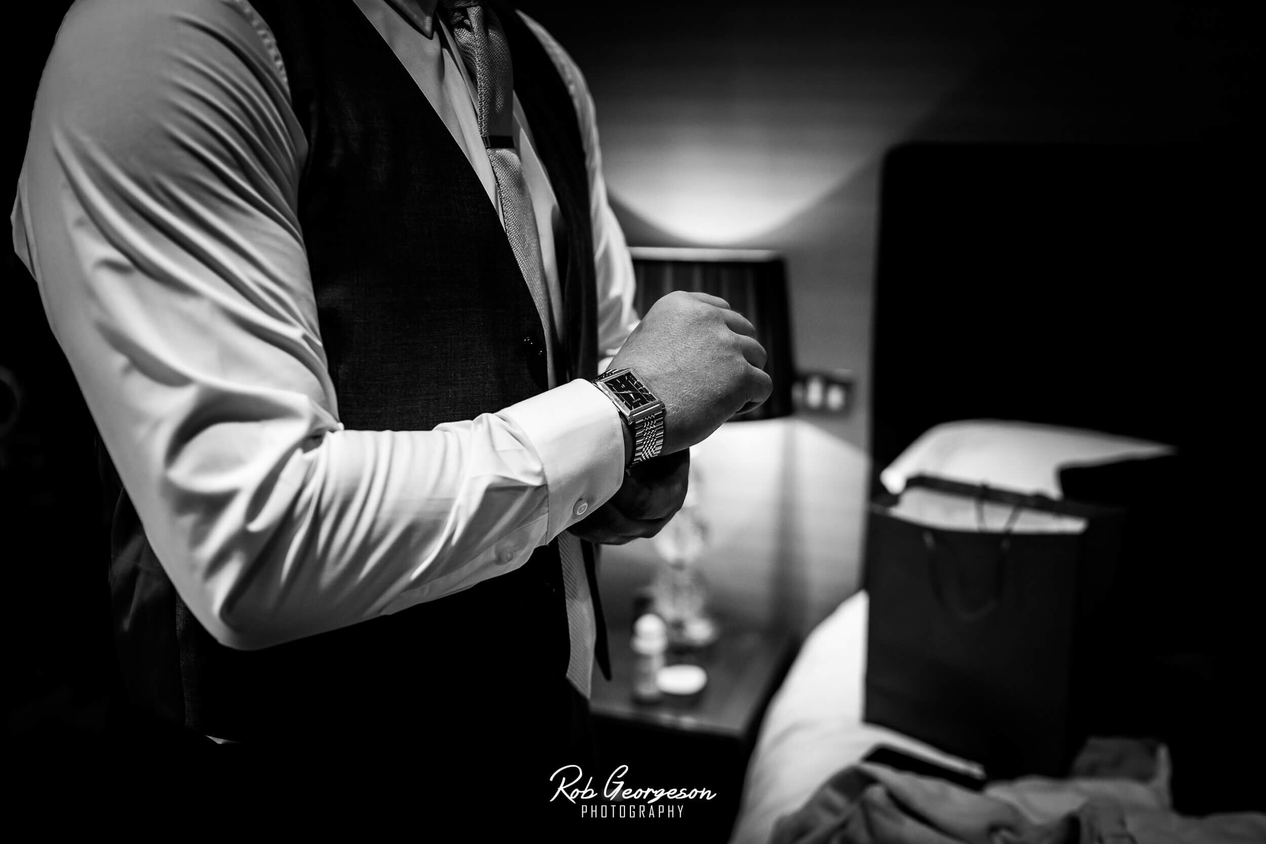 groom putting his watch on 
