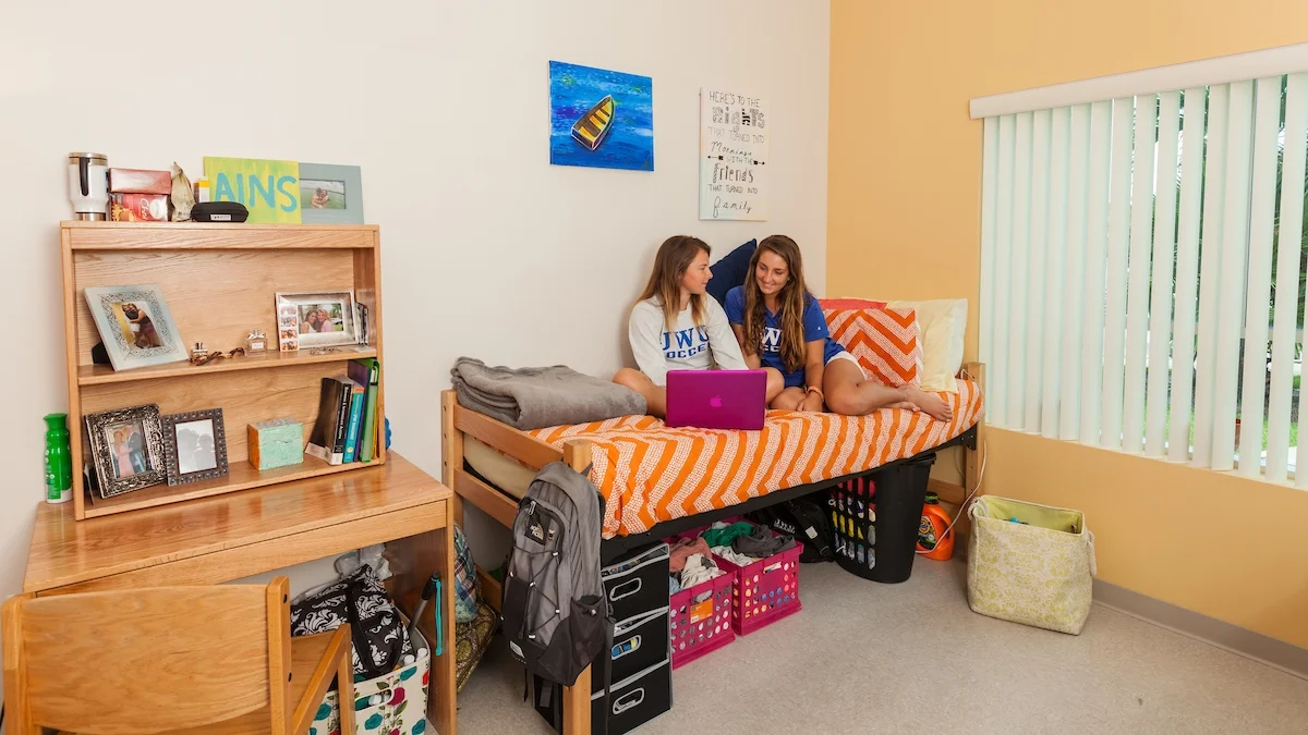 JWU resident students sit on bed