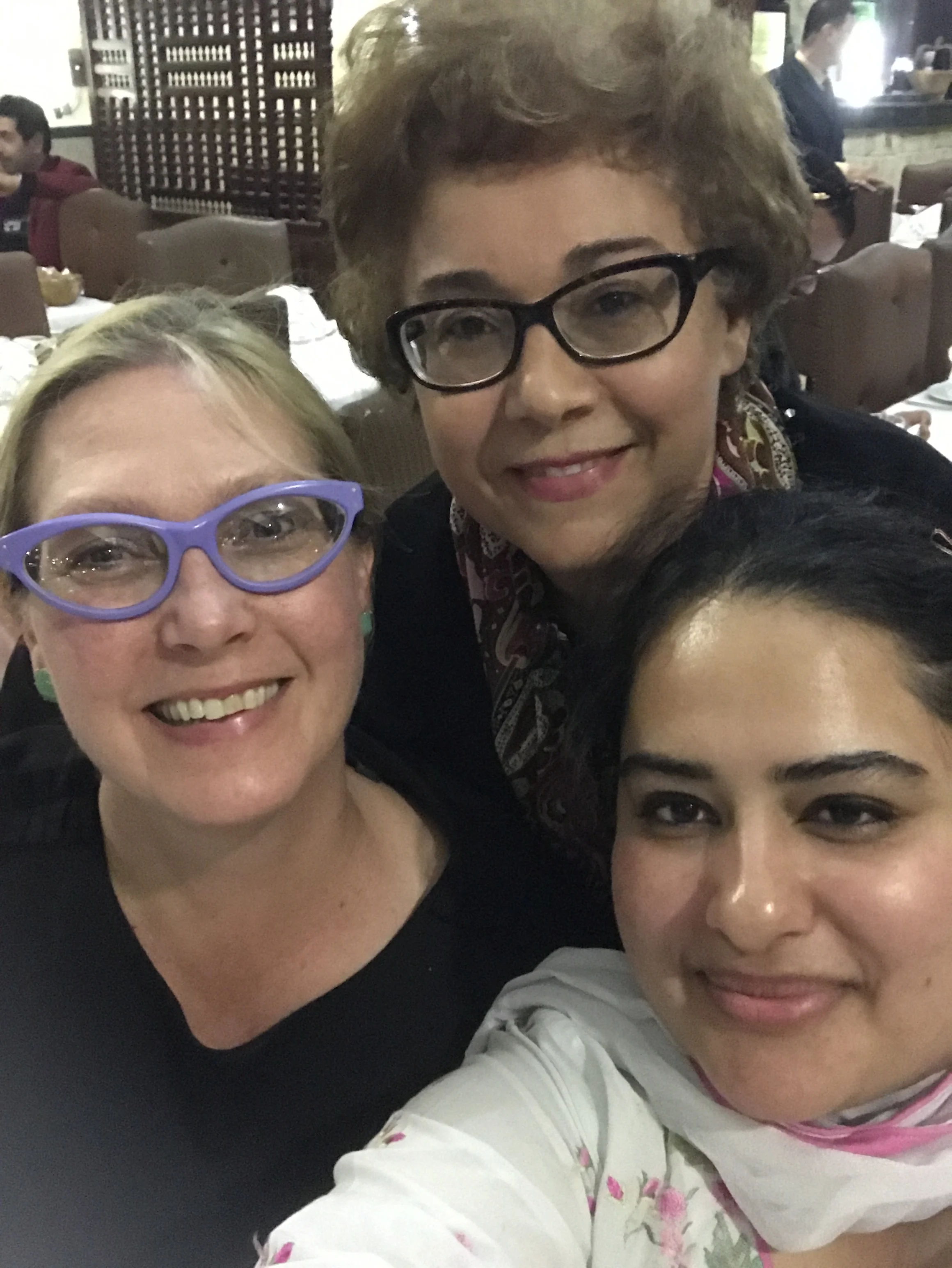 Ashley, Raja, and Zahra pose for a casual selfie at the final dinner with the team and participants.
