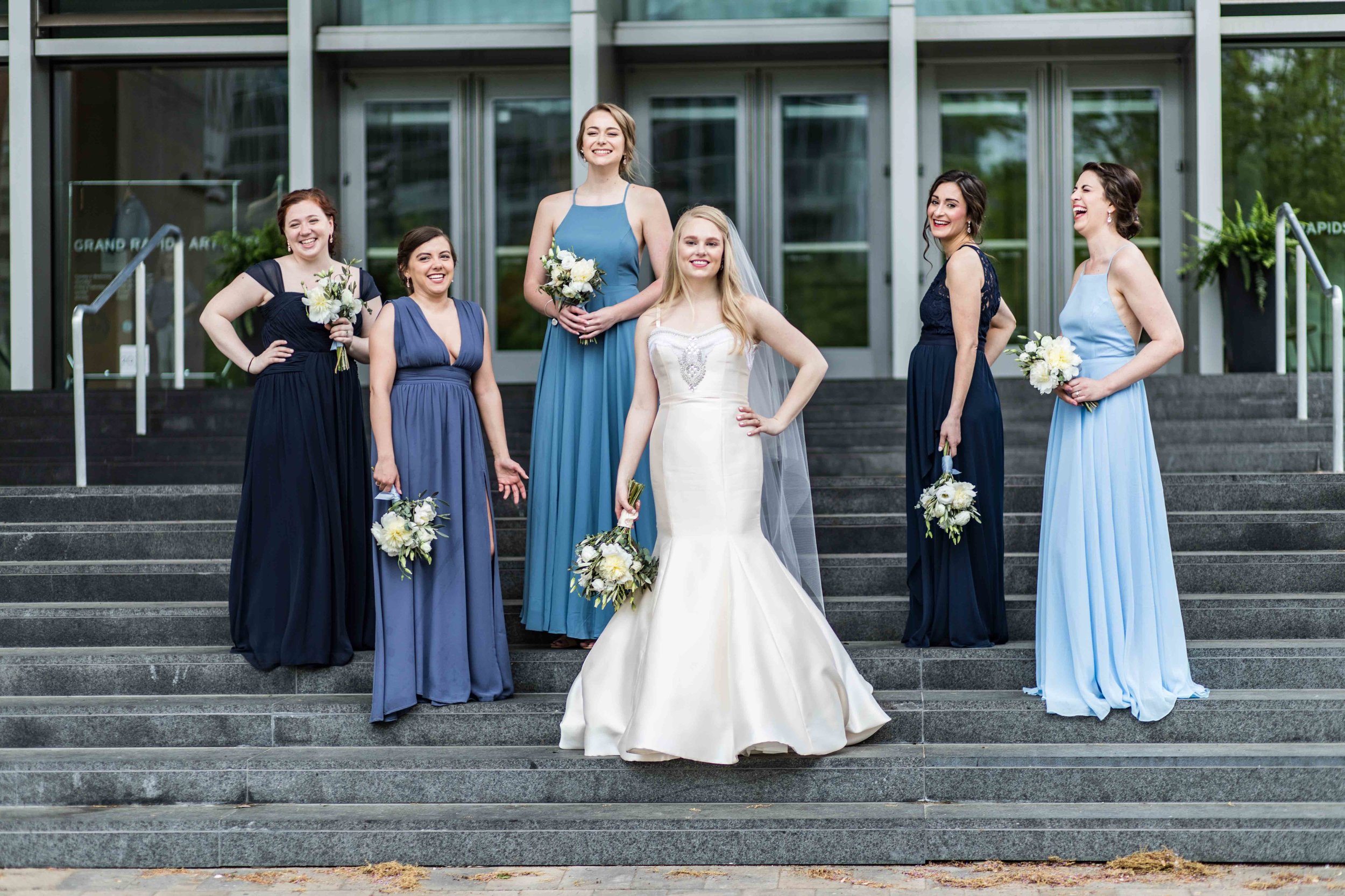  The bridesmaids posing on steps with the Bride 