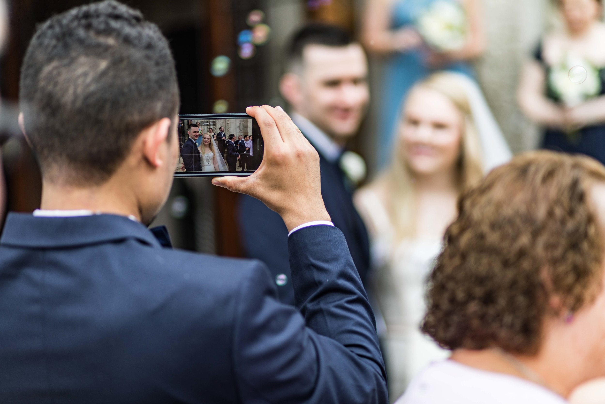  Groomsman taking iphone photo of bride and groom 