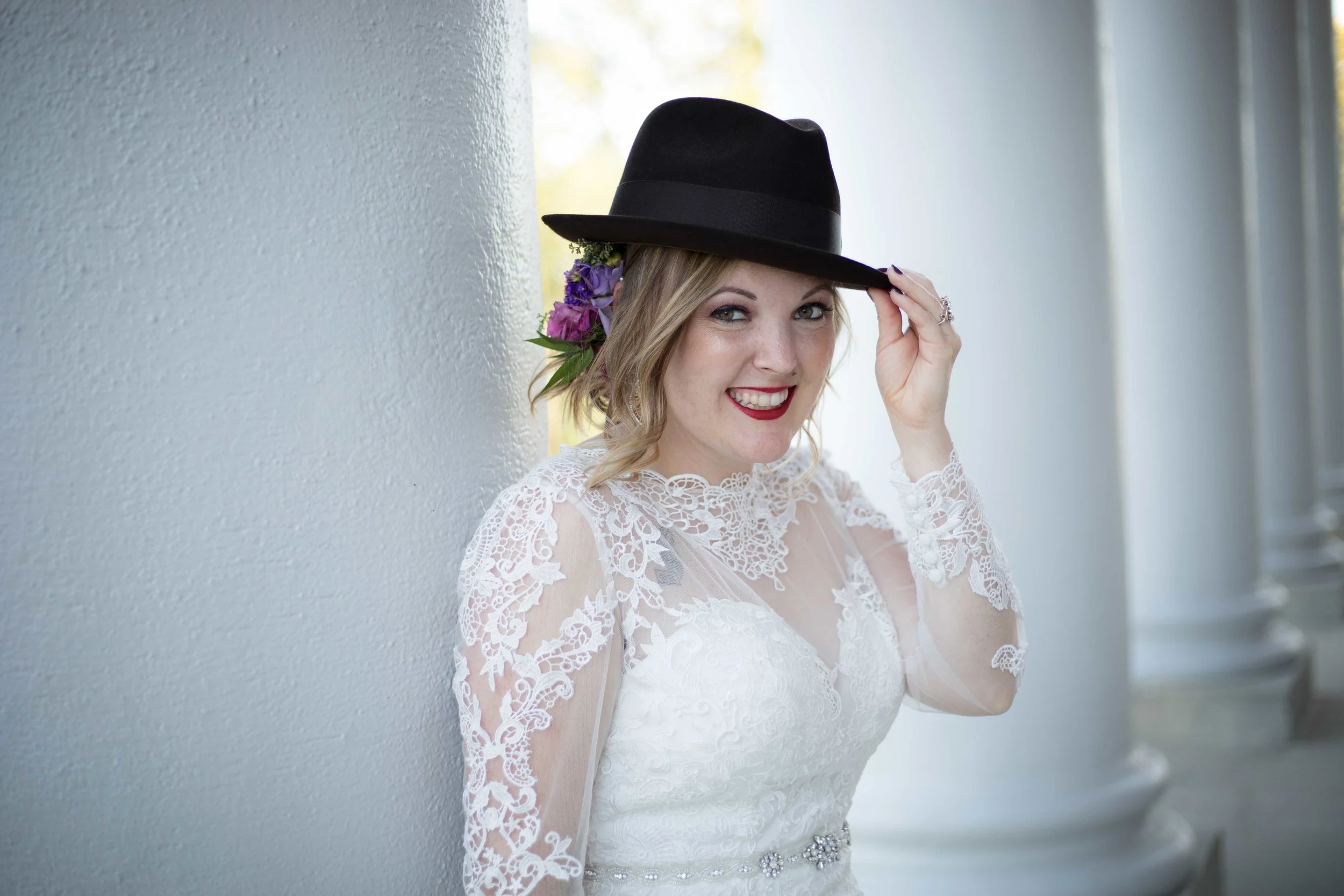 The bride sporting the grooms hat at heritage hall on western michigan university’s campus
