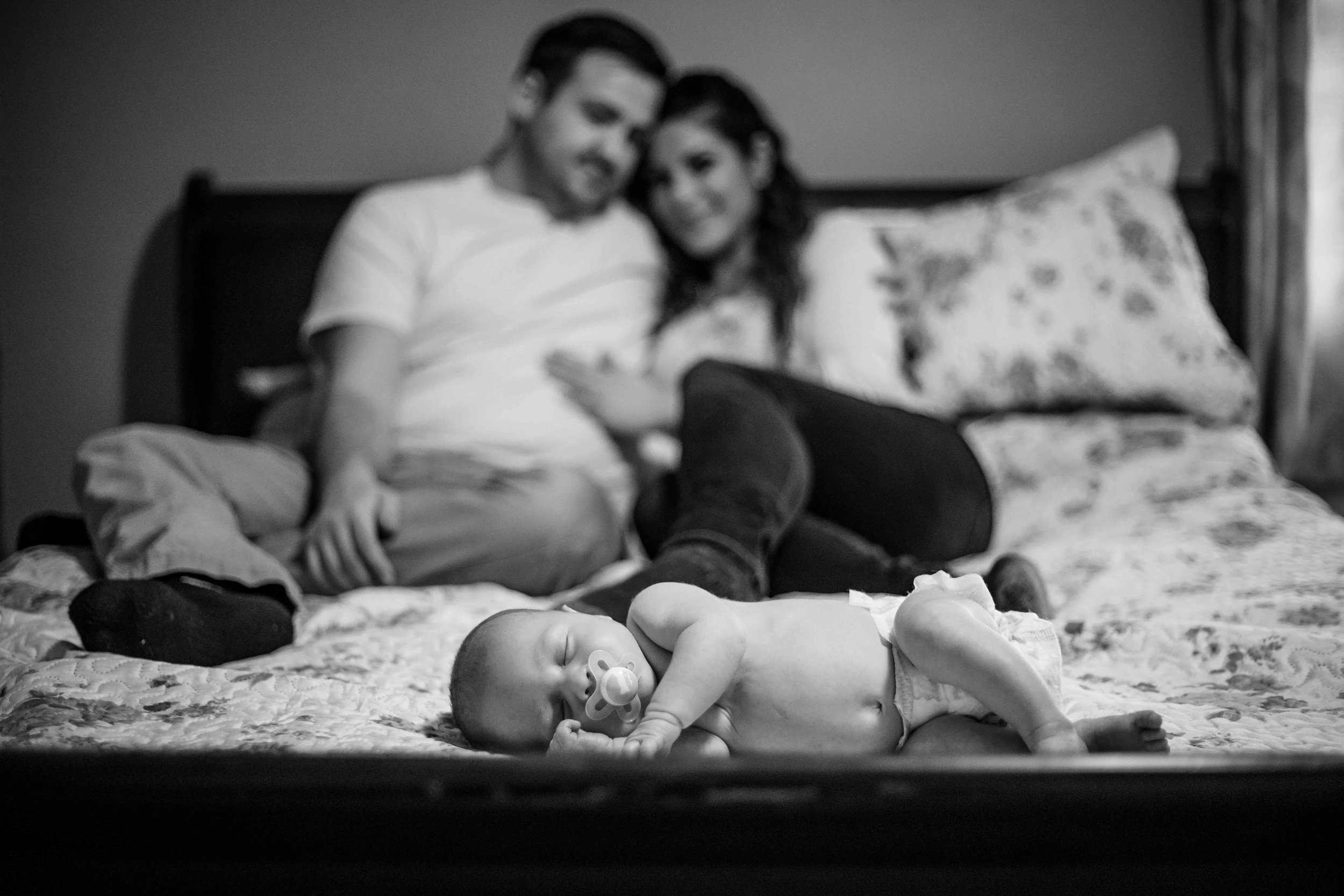 CDP Baby laying on bed with mom and dad.jpg