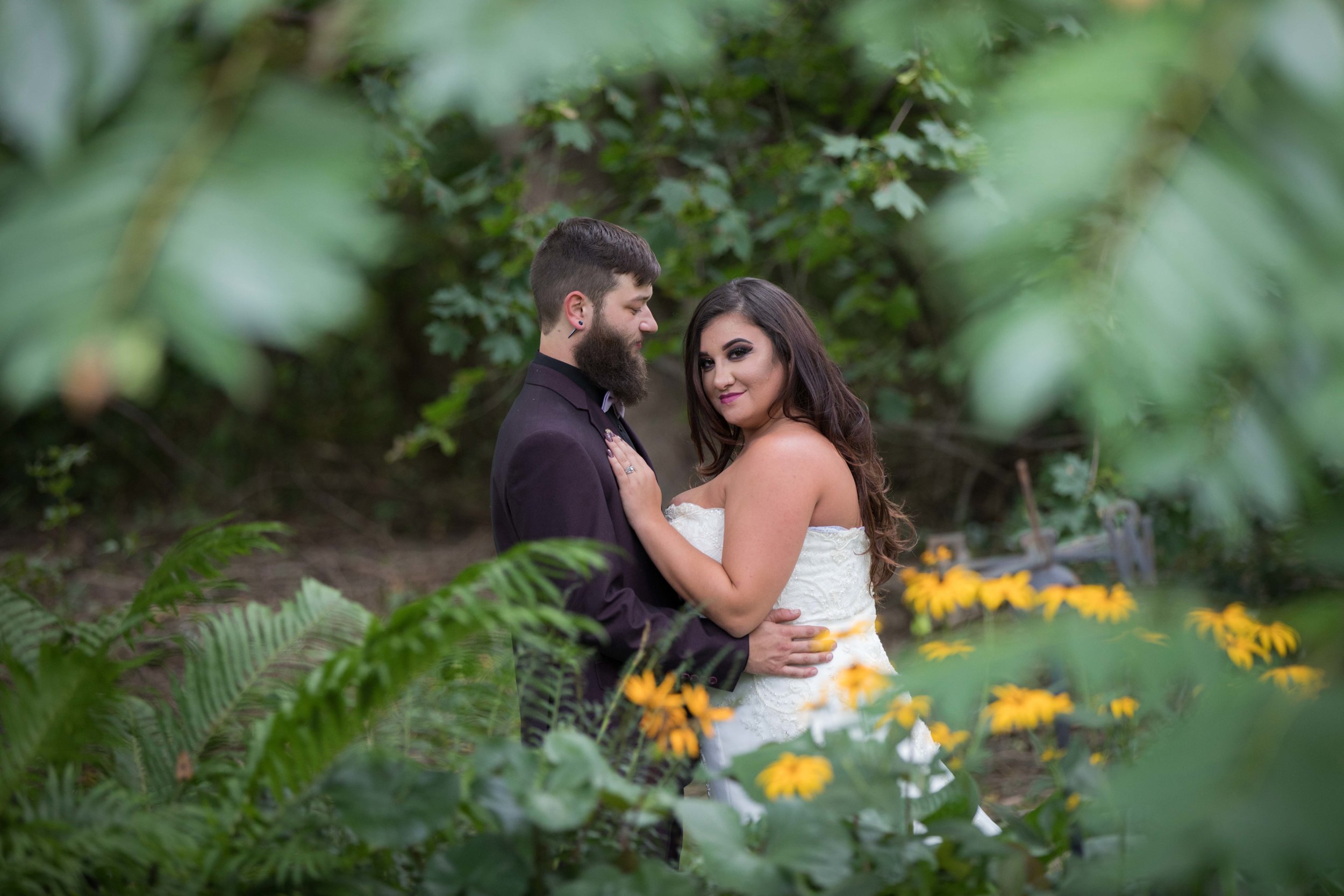 bride and groom pose for portrait through trees.jpg