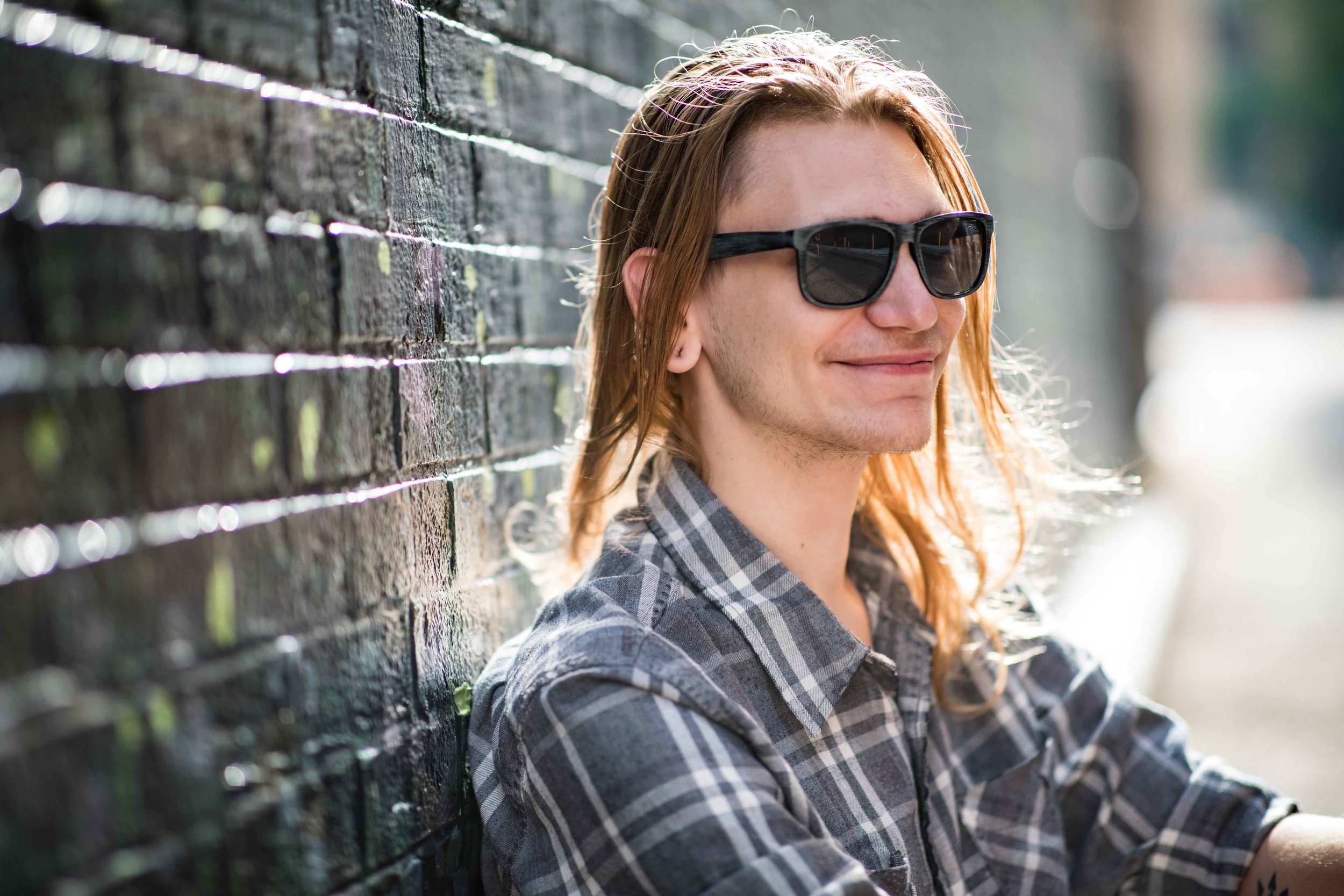 CDP Morgan With sunglasses sitting against a painted wall.jpg