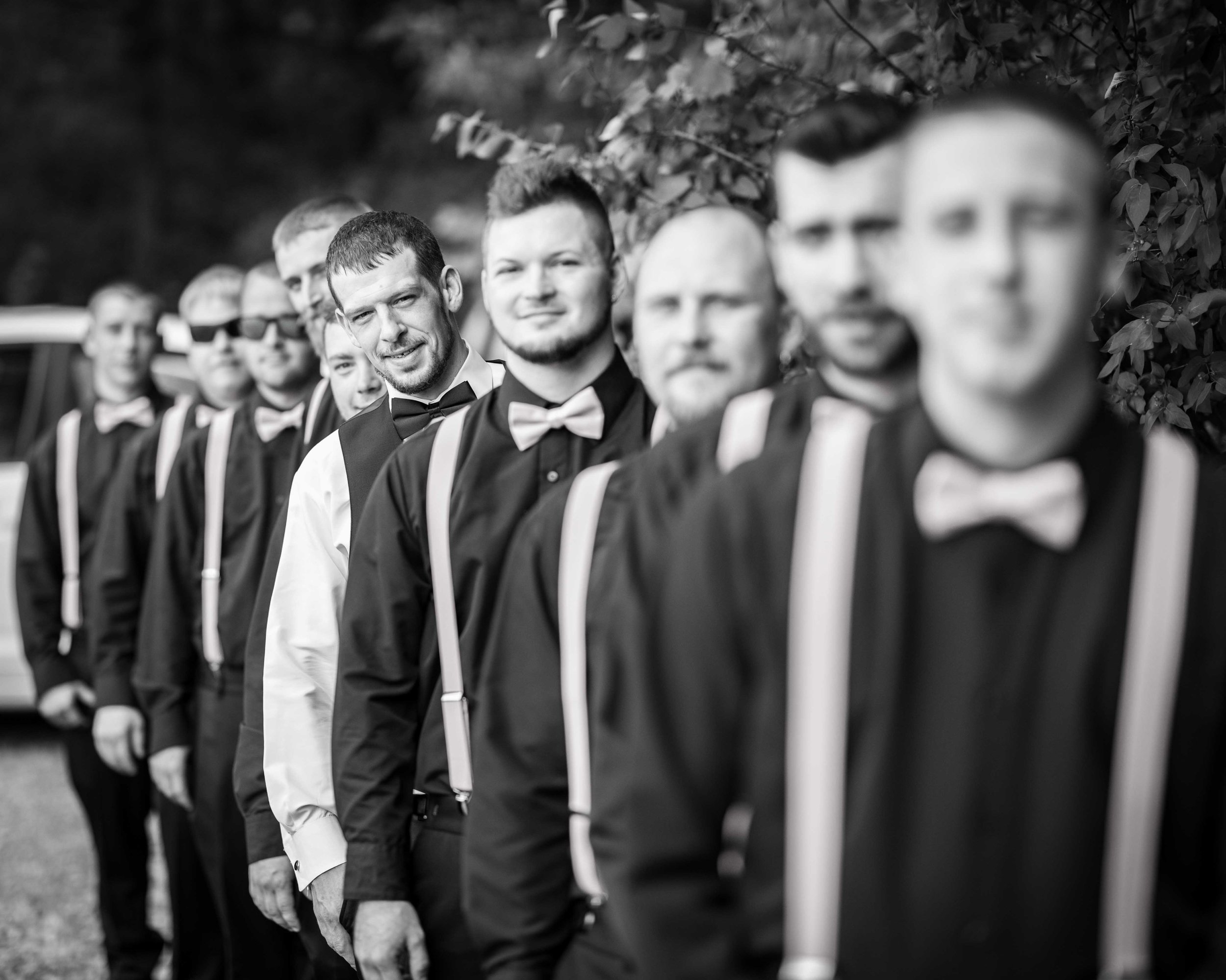  Grooms wedding party lines up for a black and white, focusing on the groom 
